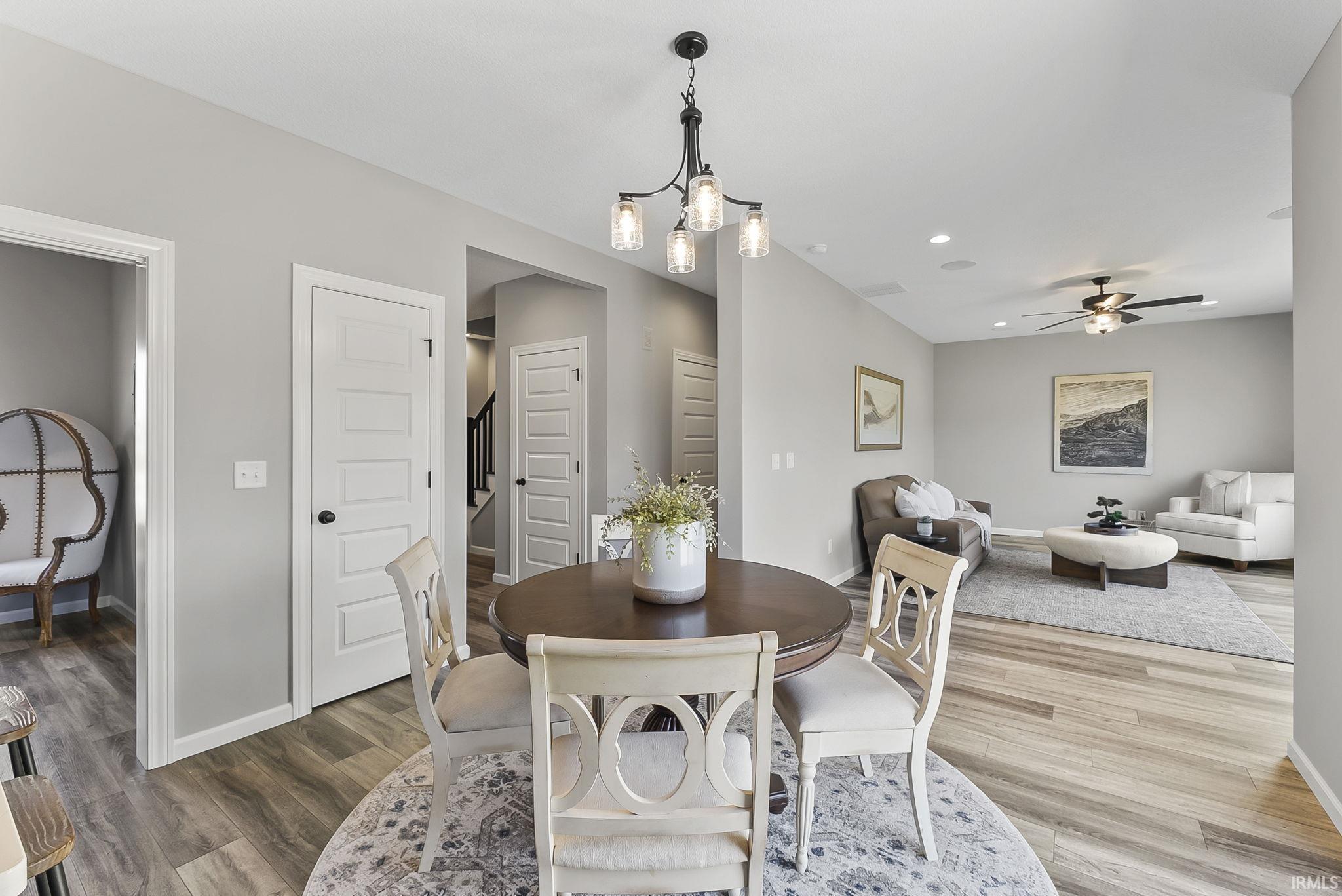 Dining room with a chandelier, ceiling fan, and wood finished floors