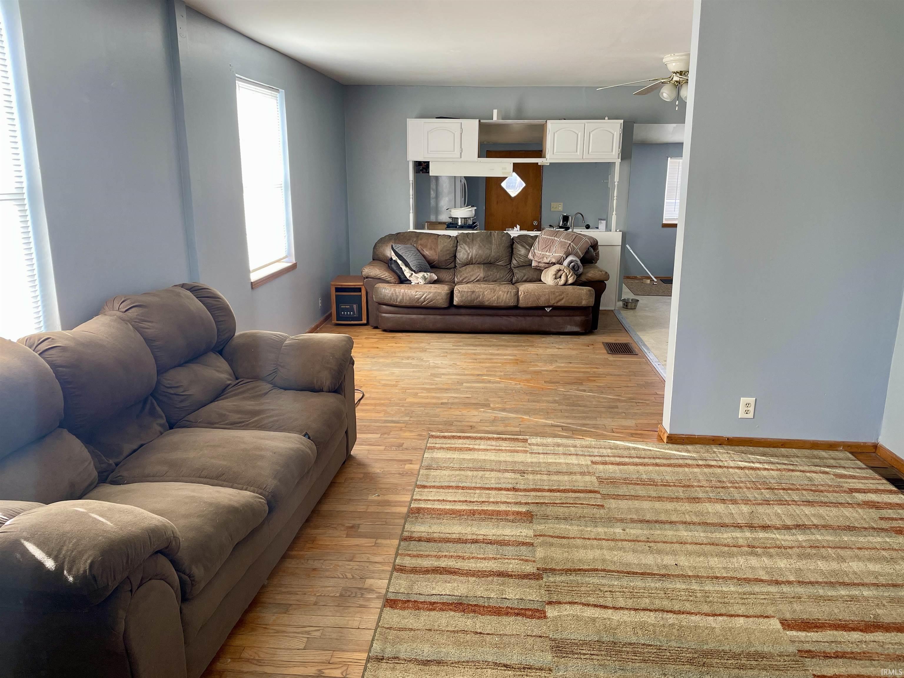 Living room featuring light wood-style flooring and a ceiling fan