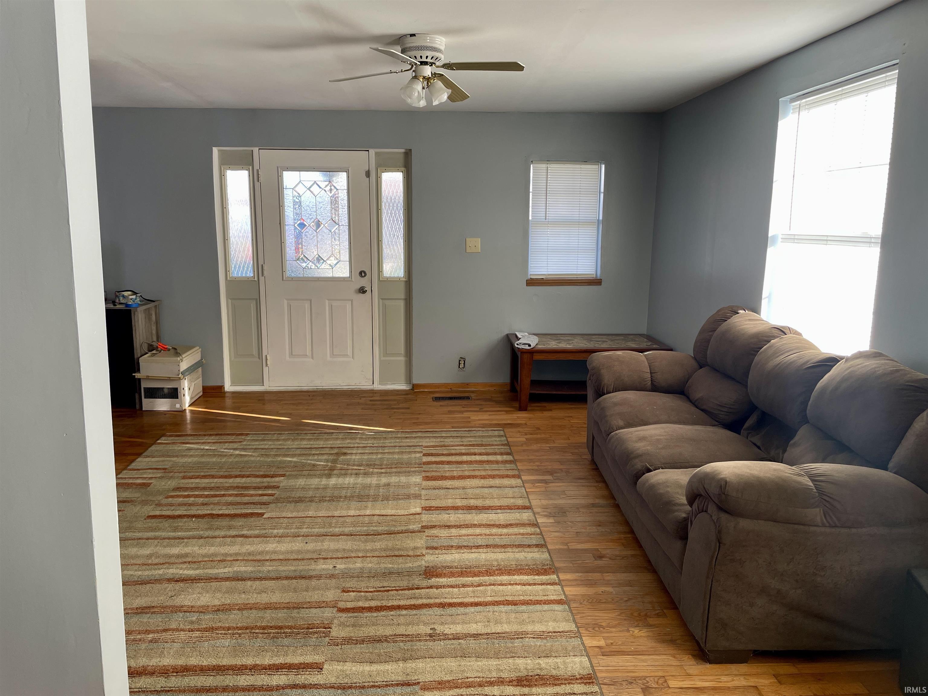 Living room featuring light wood finished floors and ceiling fan
