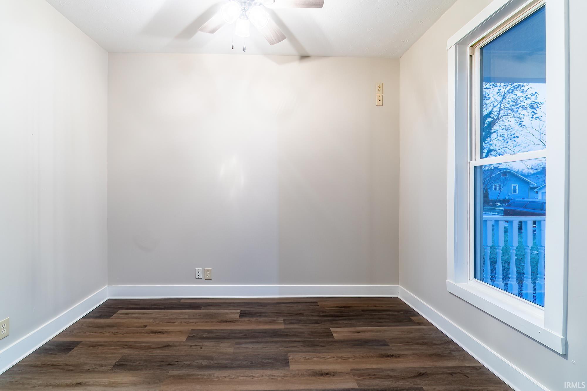 Spare room with dark wood-style floors and ceiling fan