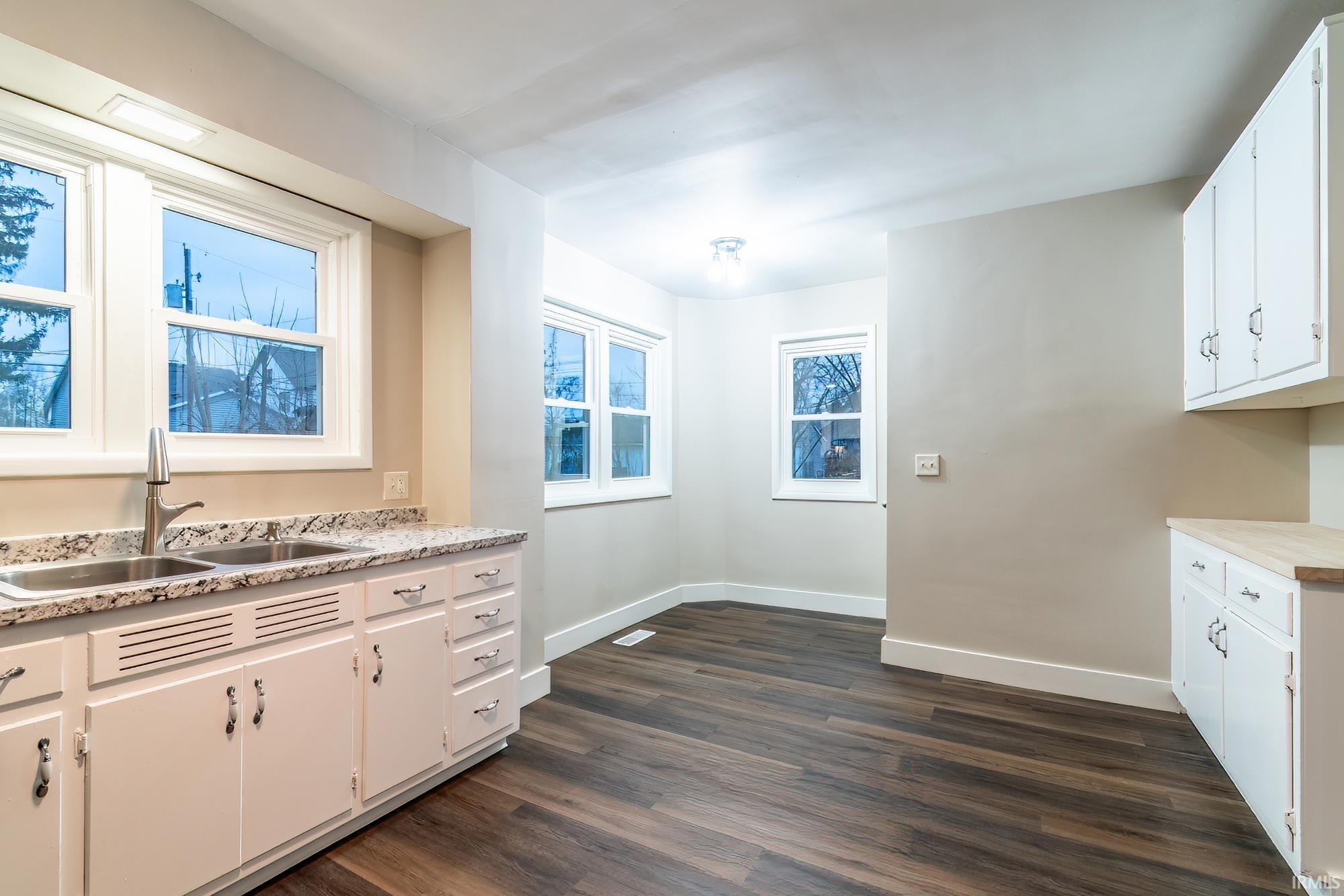 Kitchen featuring white cabinets and dark wood-style floors