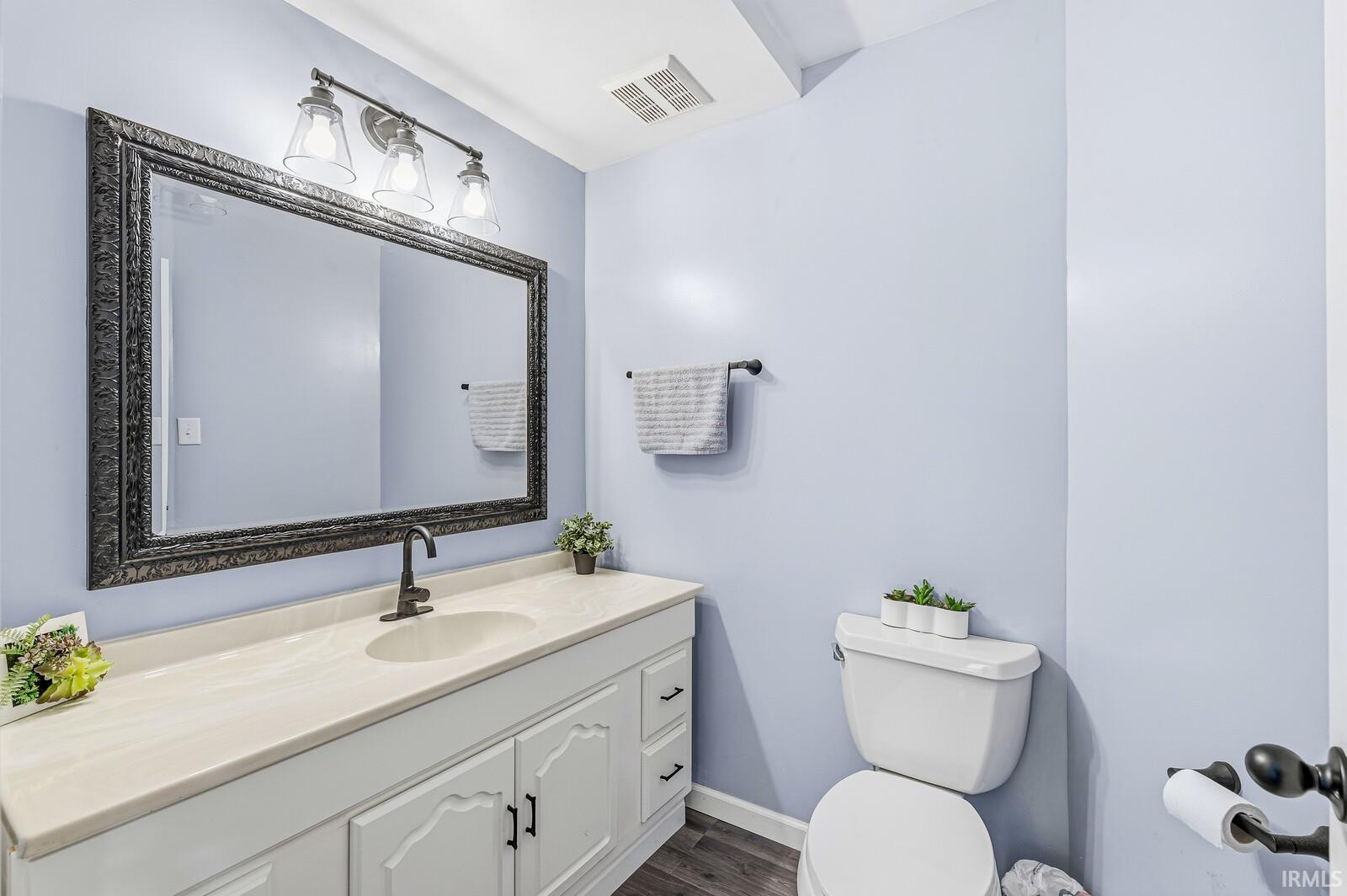 Half bath featuring vanity and dark wood finished floors