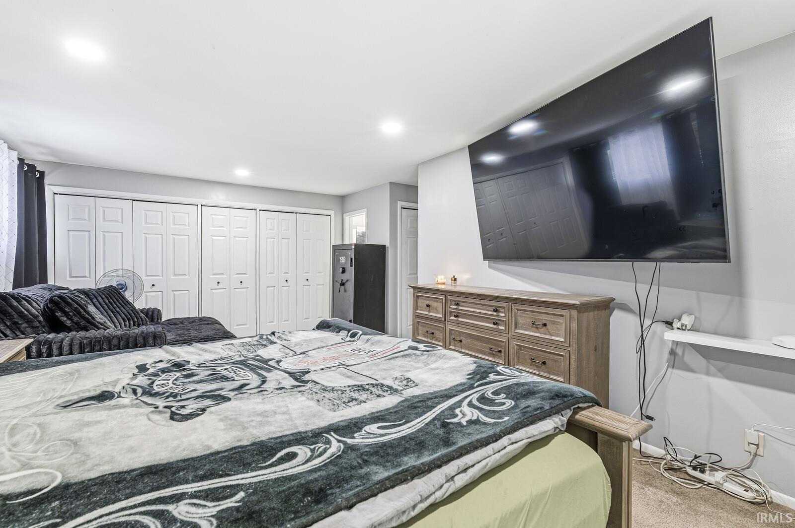 Bedroom with light colored carpet and recessed lighting