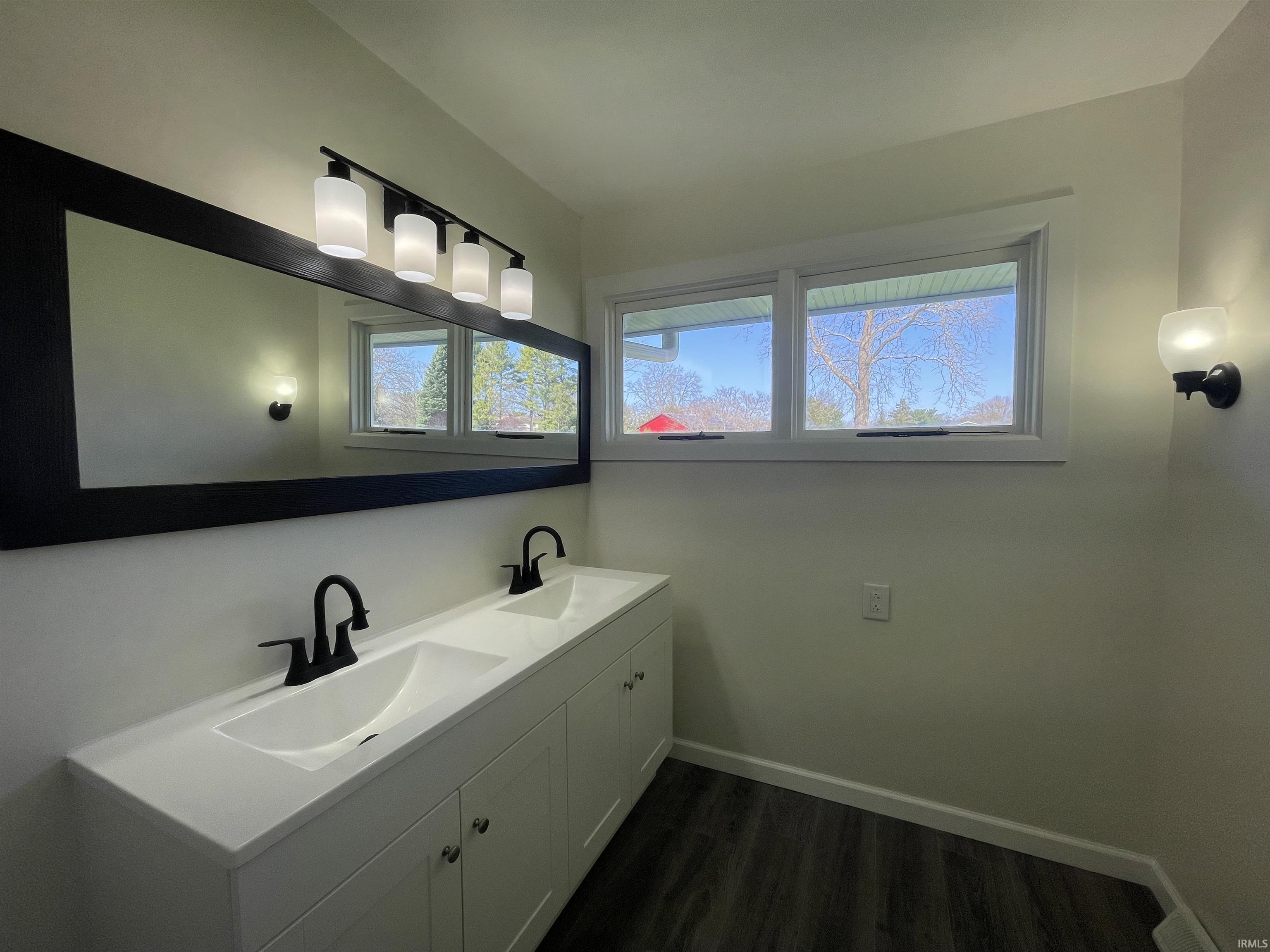 Full bathroom featuring vanity, tile walls, wainscoting, light tile patterned flooring, and a shower stall