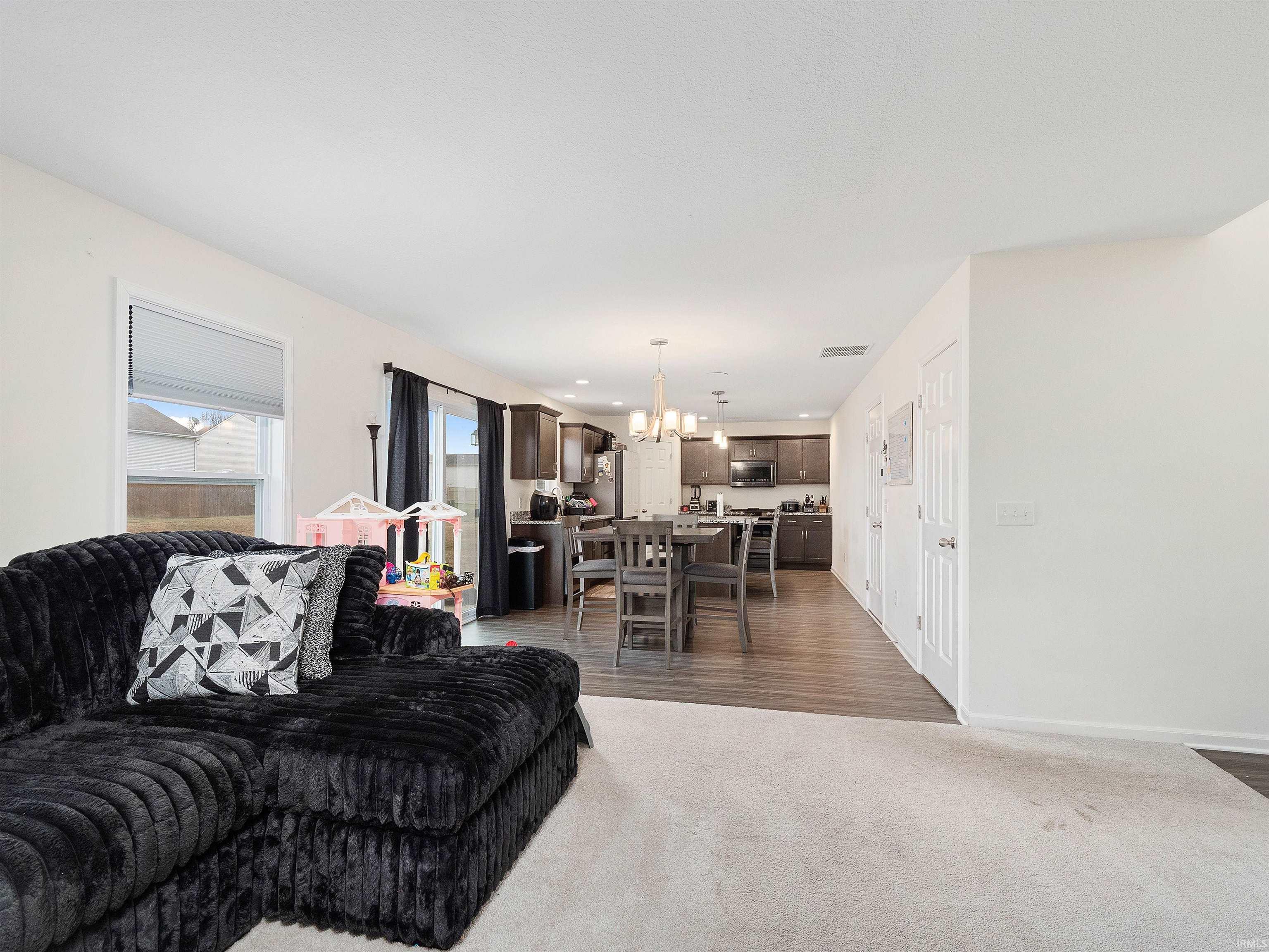Living area with a chandelier and dark colored carpet