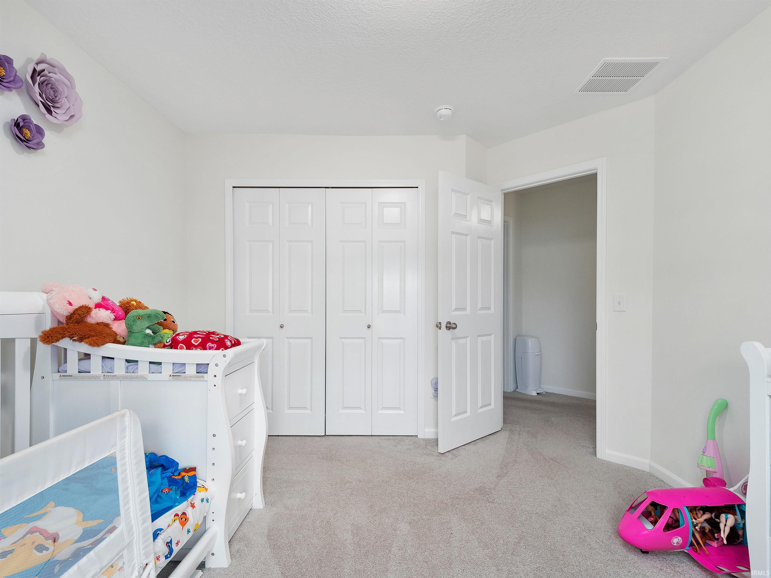 Bedroom with light carpet and a closet