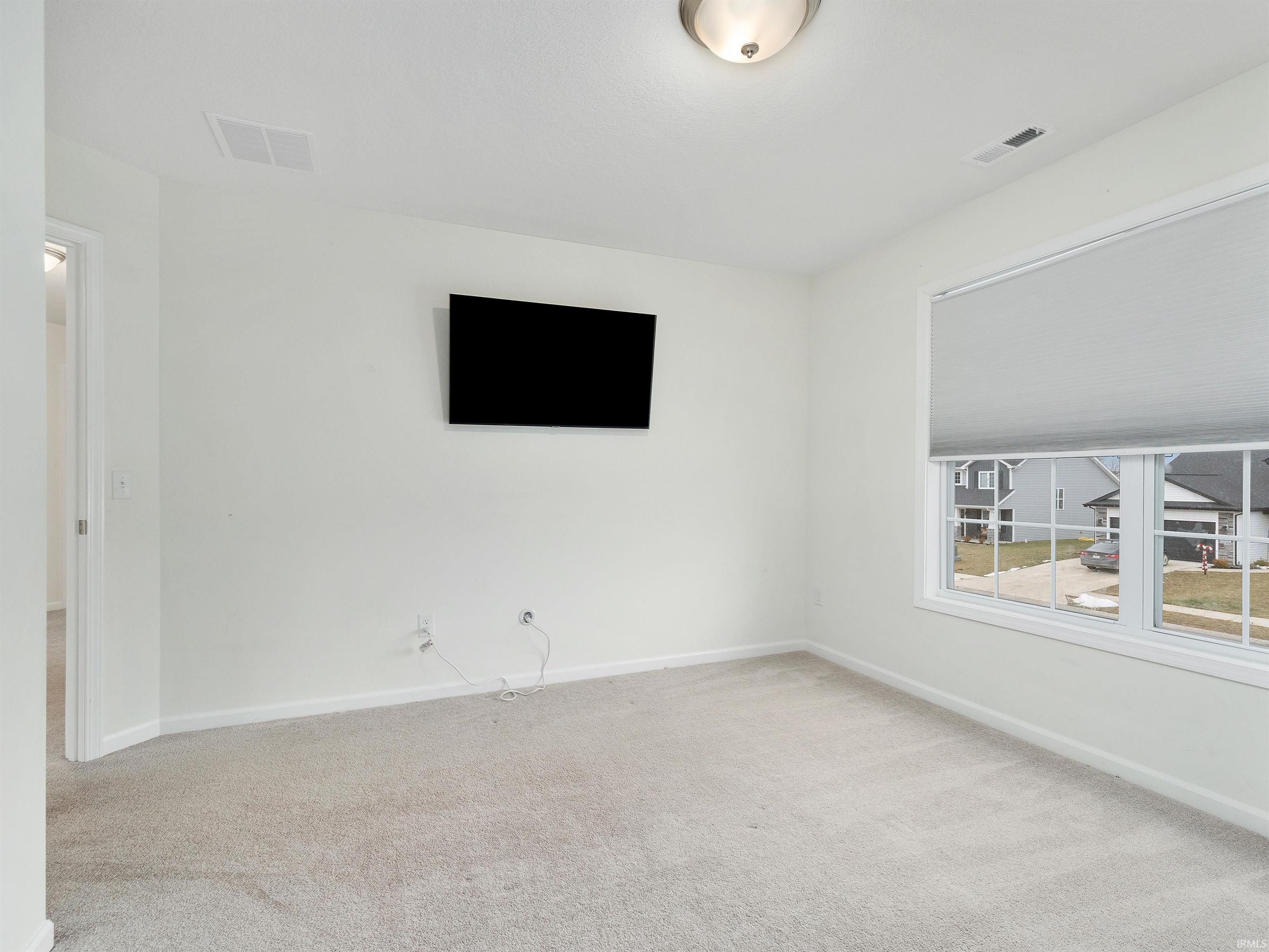 Spare room with light carpet and baseboards