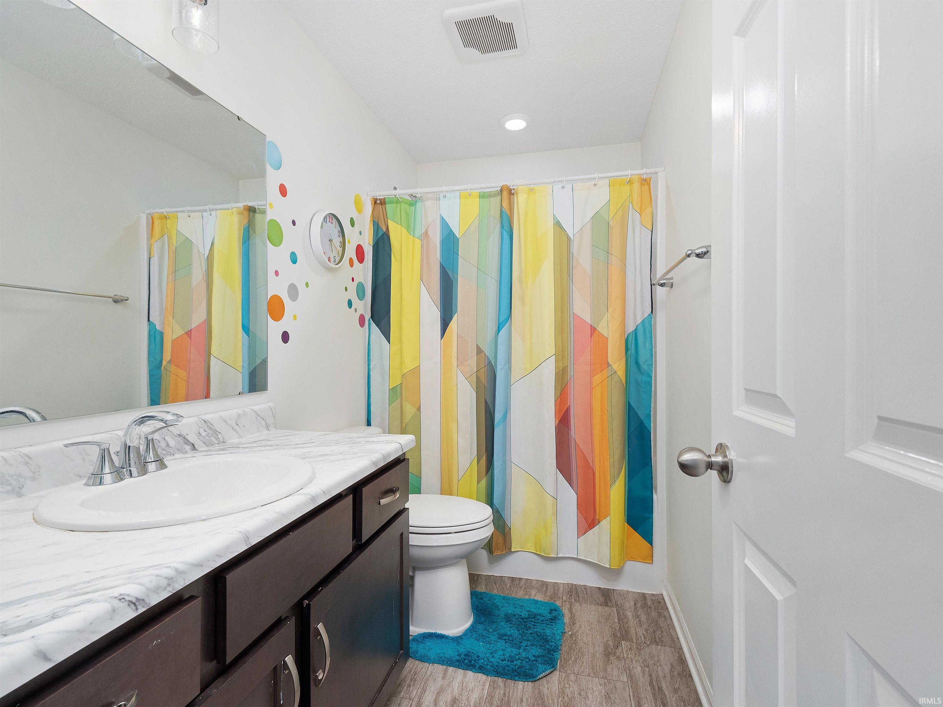 Bathroom with a shower with curtain, vanity, and light wood finished floors