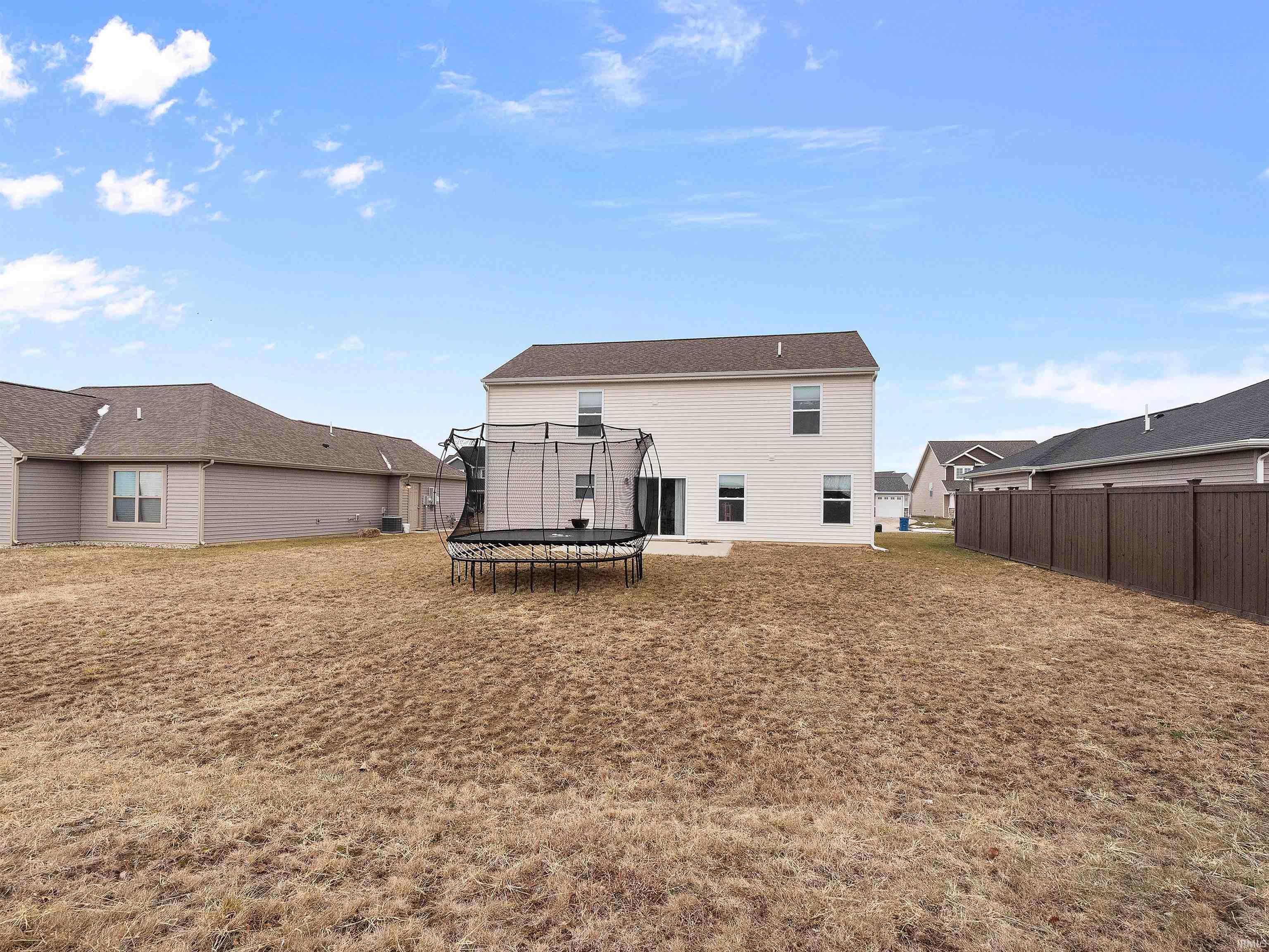 Back of house featuring a trampoline