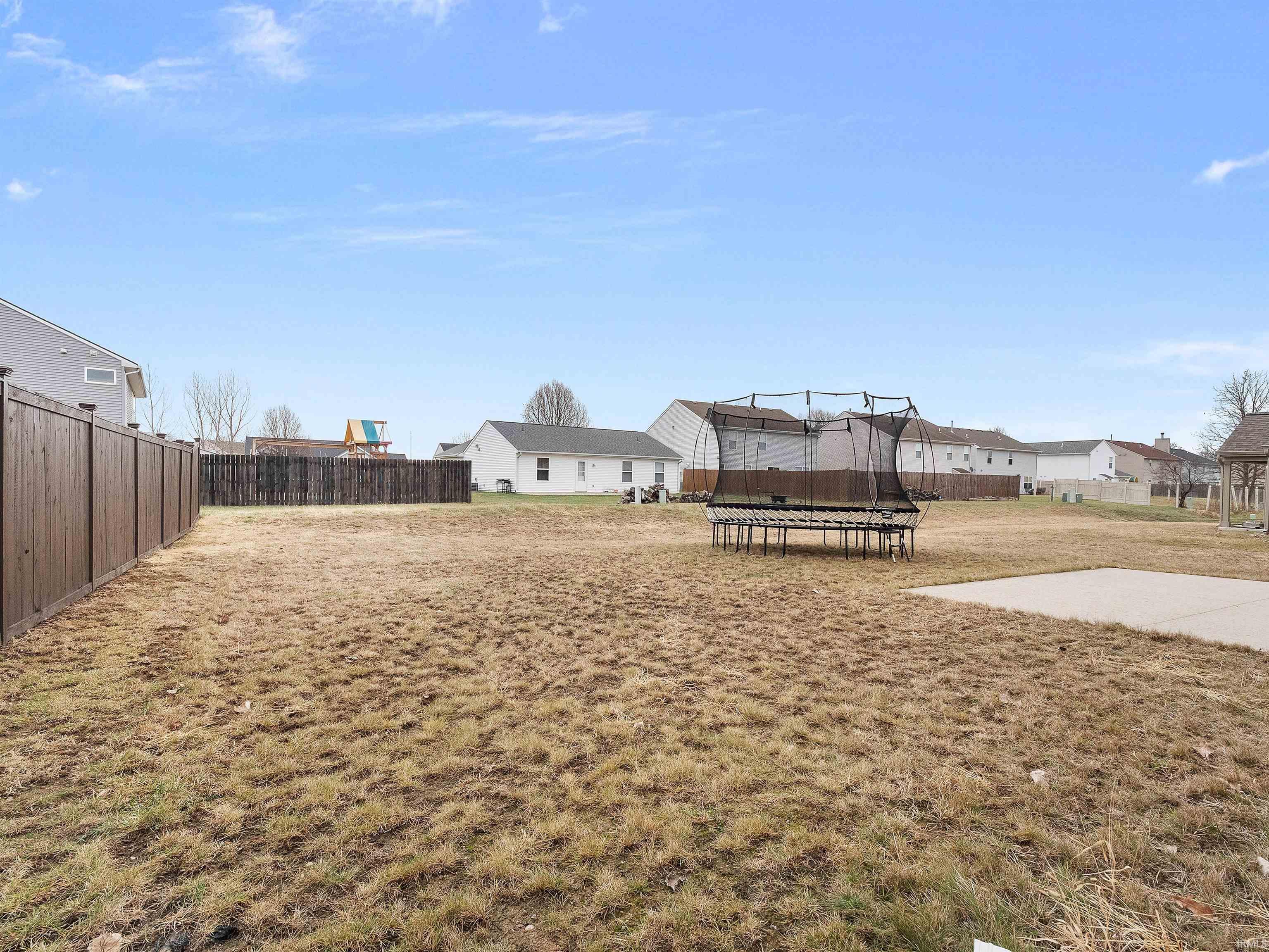 View of yard featuring a trampoline and a residential view