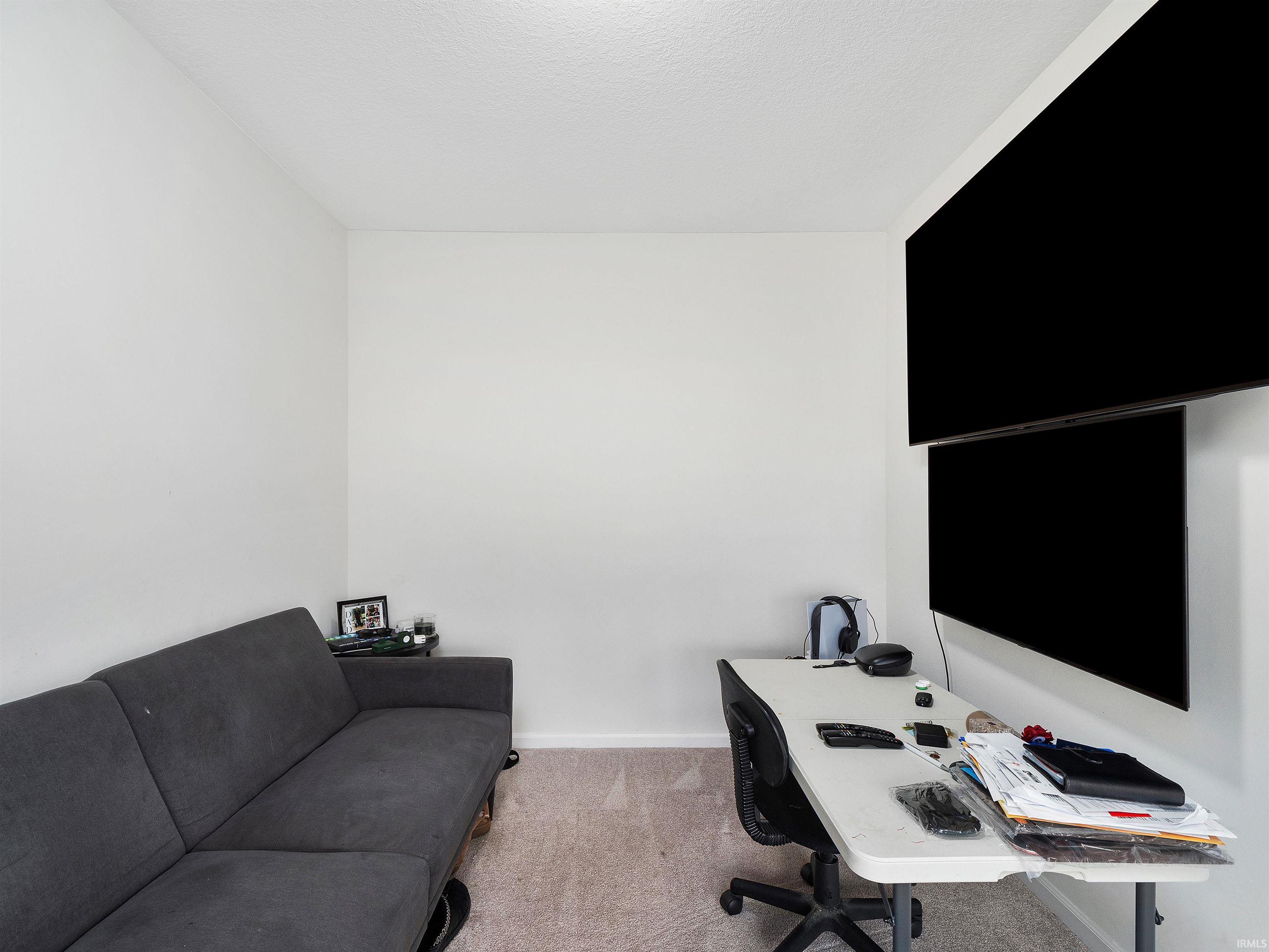 Office area with carpet and a textured ceiling