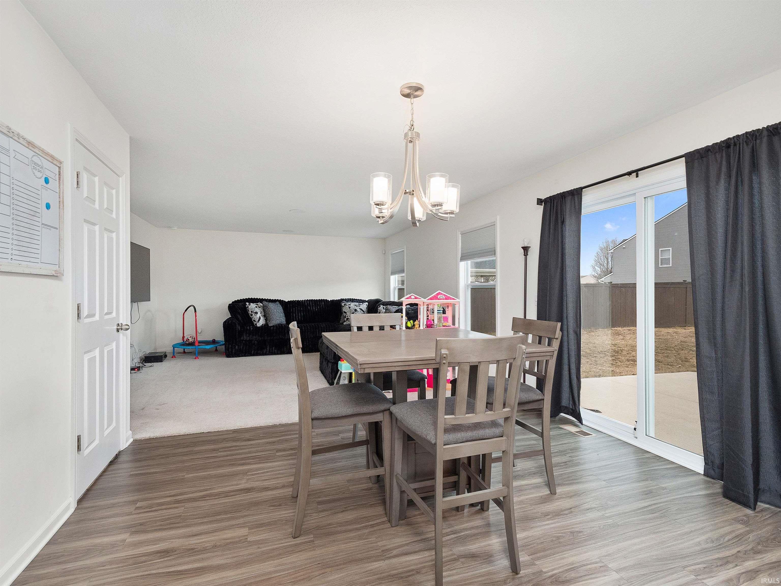 Dining room with a chandelier, healthy amount of natural light, and light wood finished floors