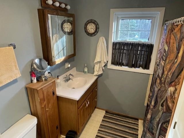 Bathroom featuring vanity, a shower with shower curtain, and light flooring