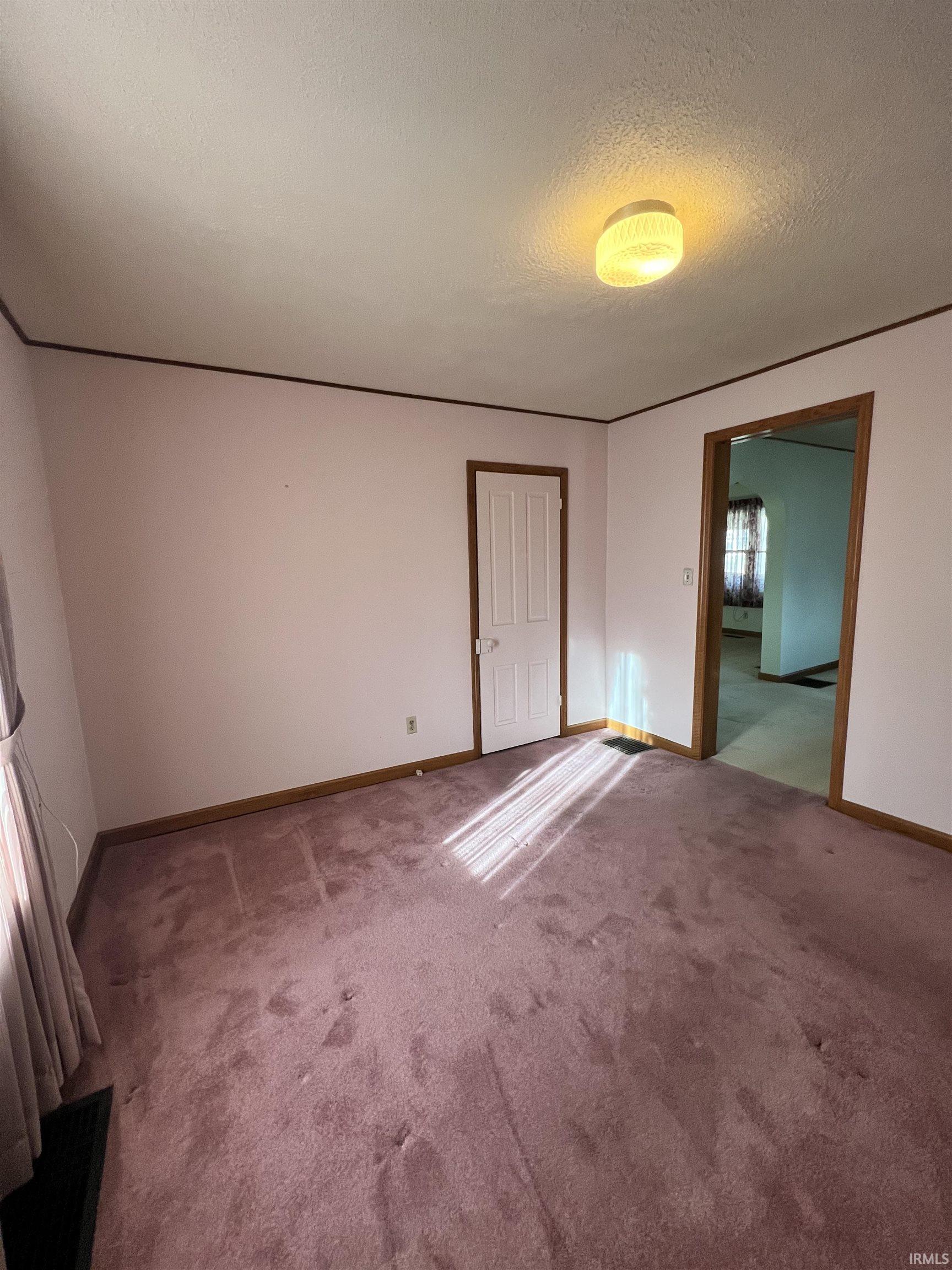 Unfurnished bedroom featuring a textured ceiling and carpet flooring