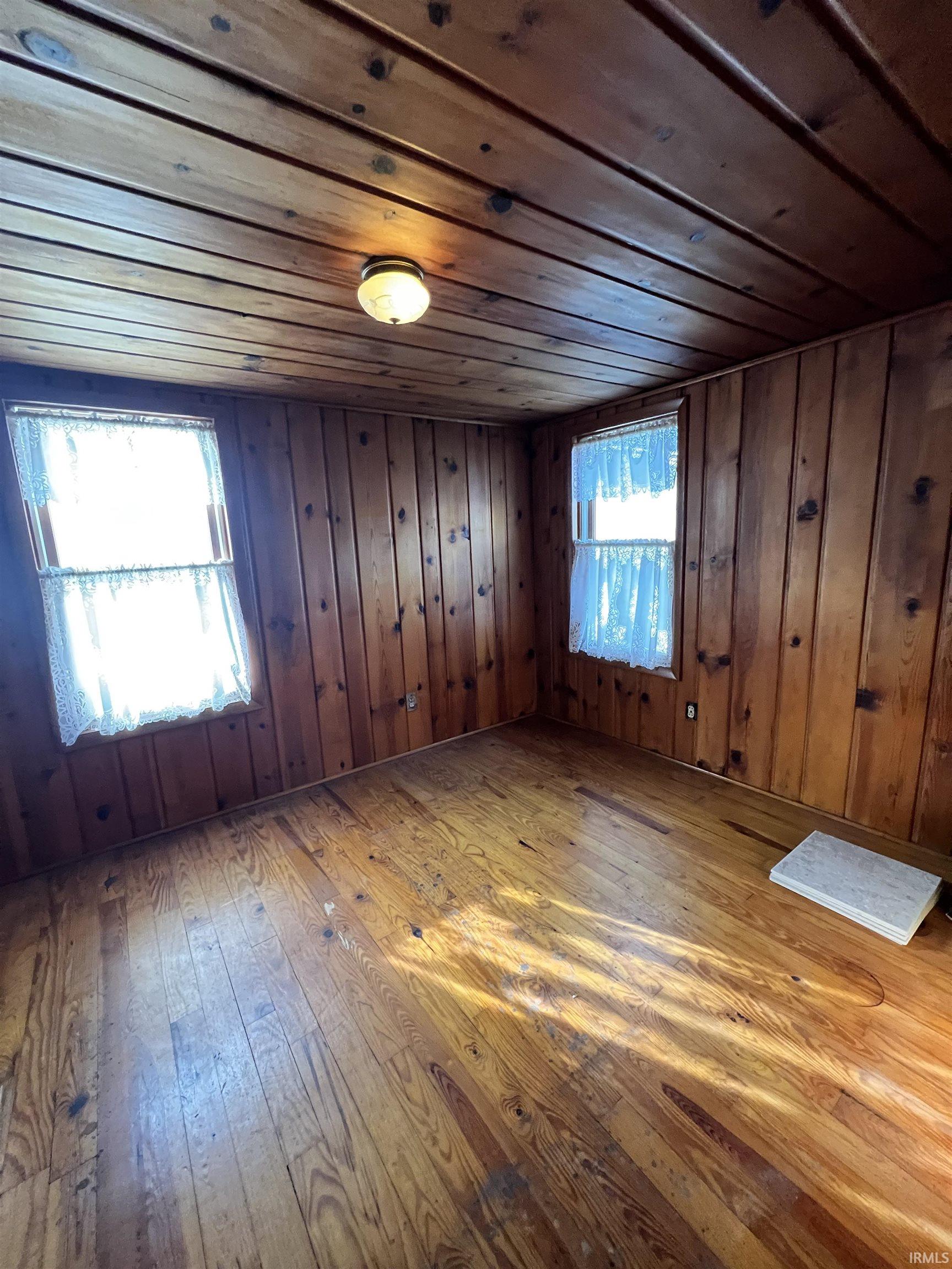 Bonus room featuring wood ceiling, hardwood / wood-style floors, and wooden walls