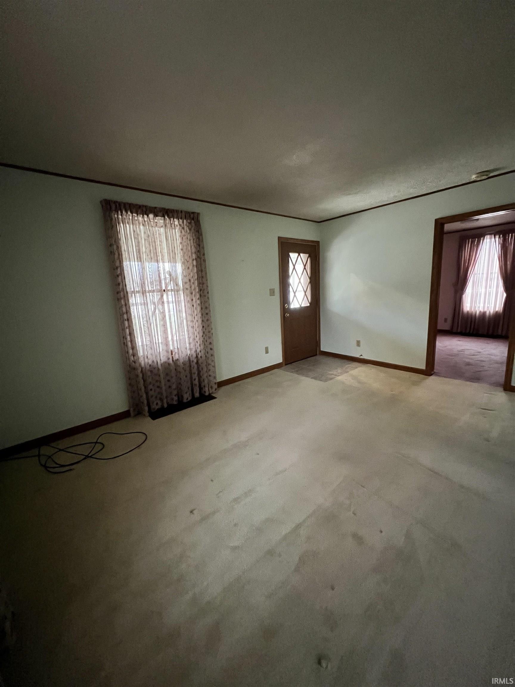 Carpeted foyer featuring baseboards