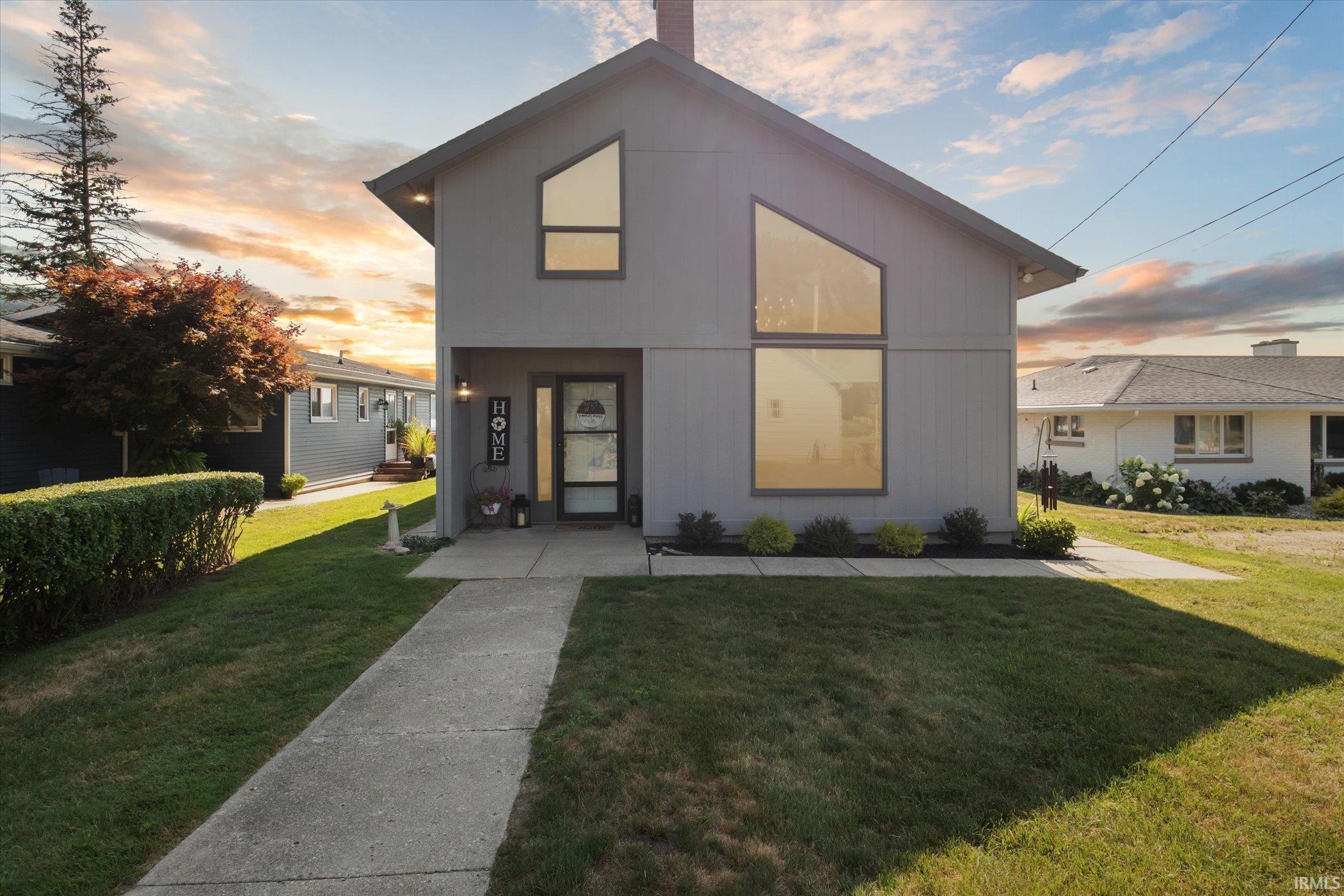 Modern home with a front lawn and a chimney