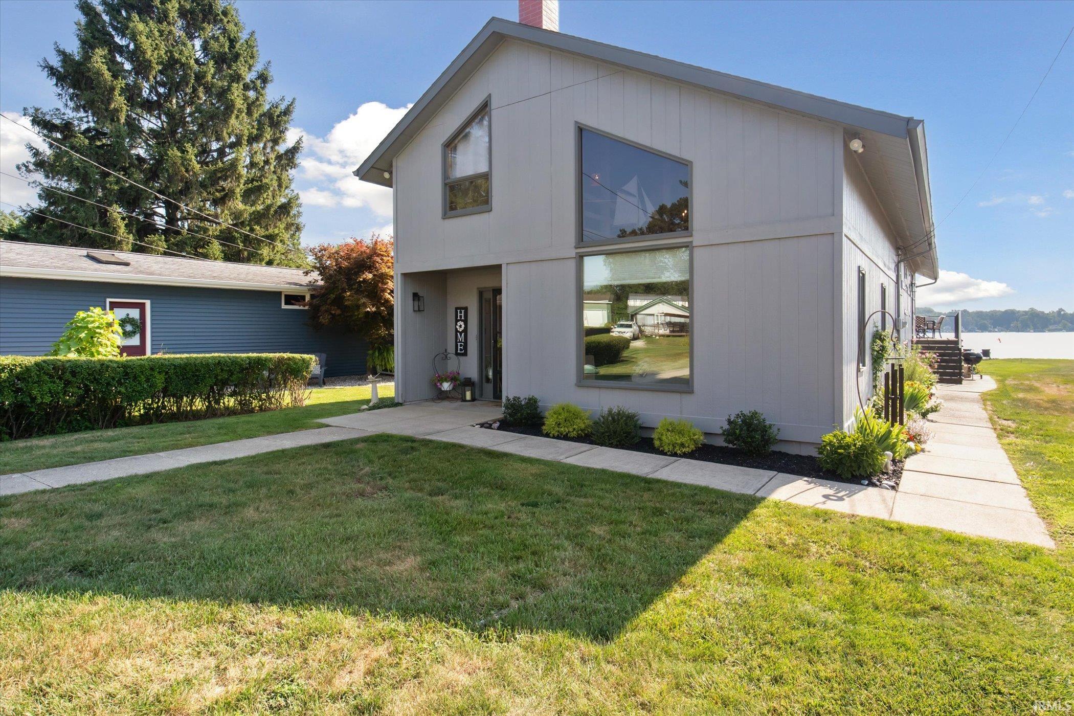 View of front facade featuring a front yard and a chimney