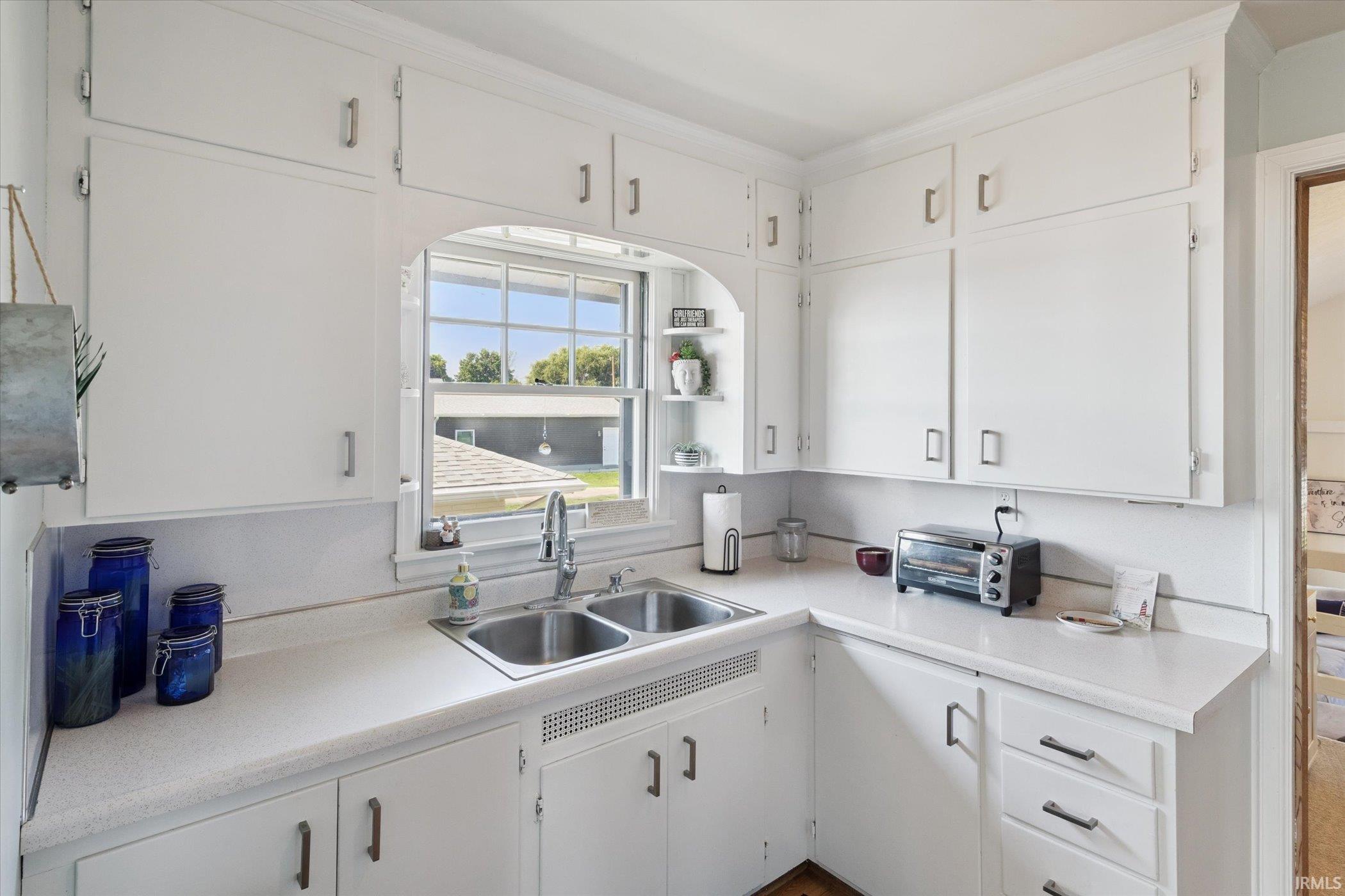 Kitchen with white cabinets, light countertops, and open shelves
