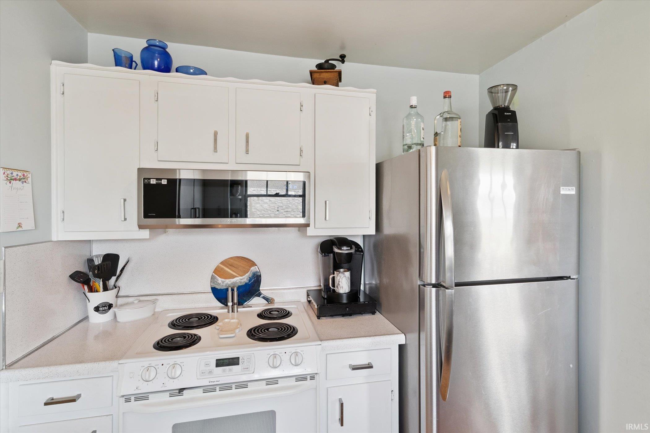 Kitchen featuring appliances with stainless steel finishes and white cabinetry