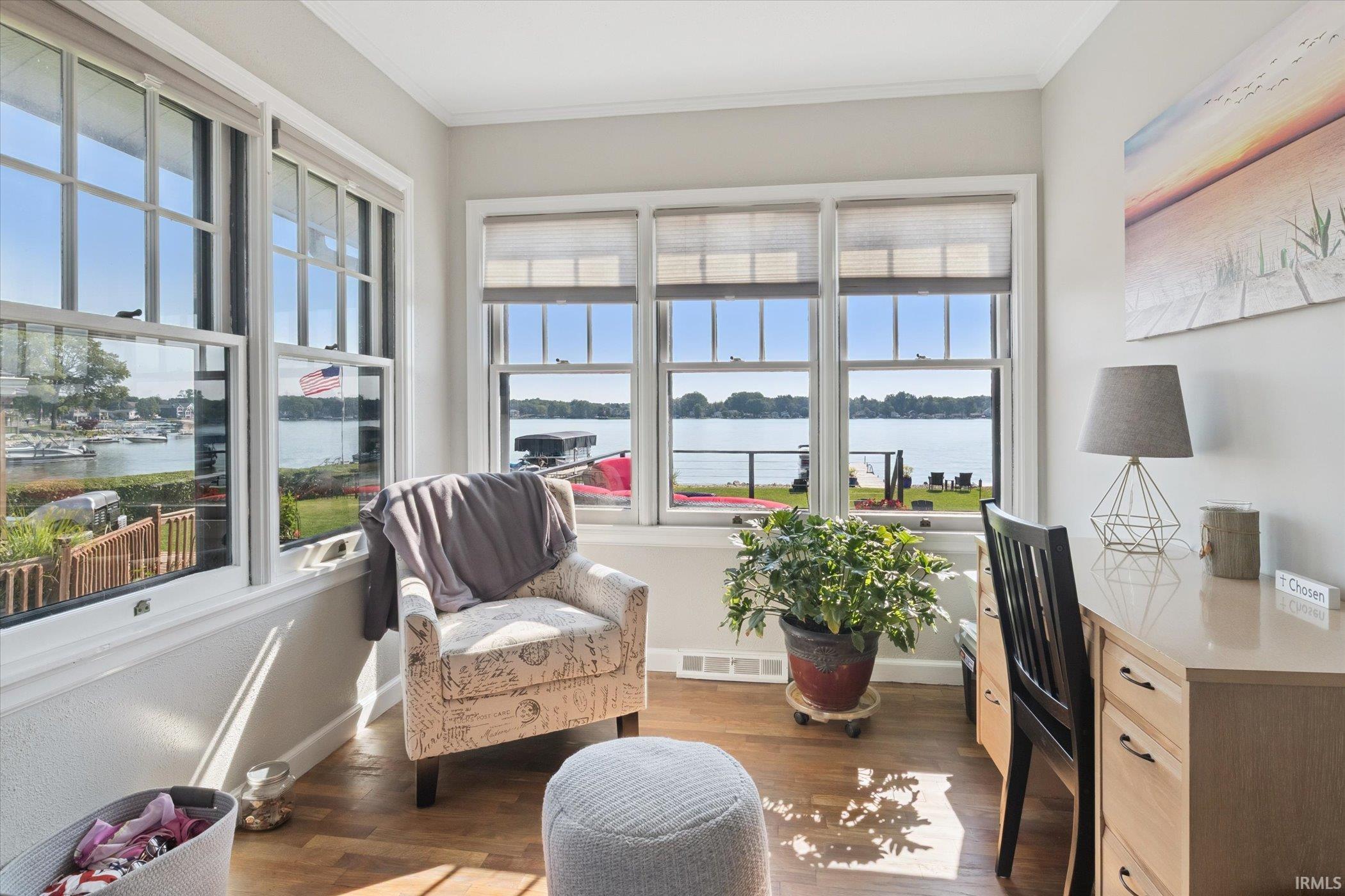 Office area featuring a water view, dark wood finished floors, and ornamental molding
