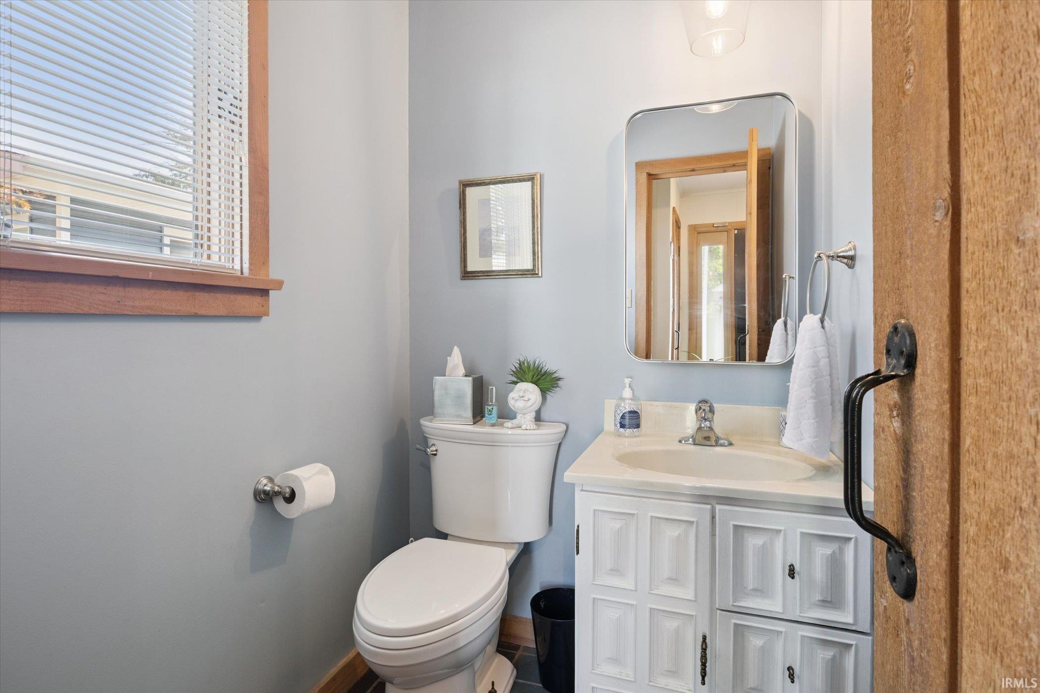 Half bathroom with vanity and healthy amount of natural light