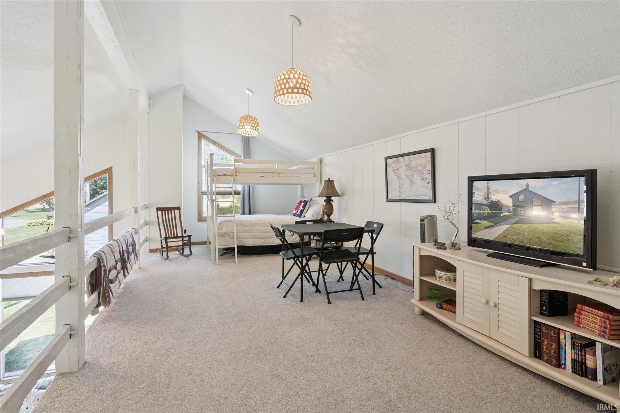 Bedroom with light colored carpet and high vaulted ceiling