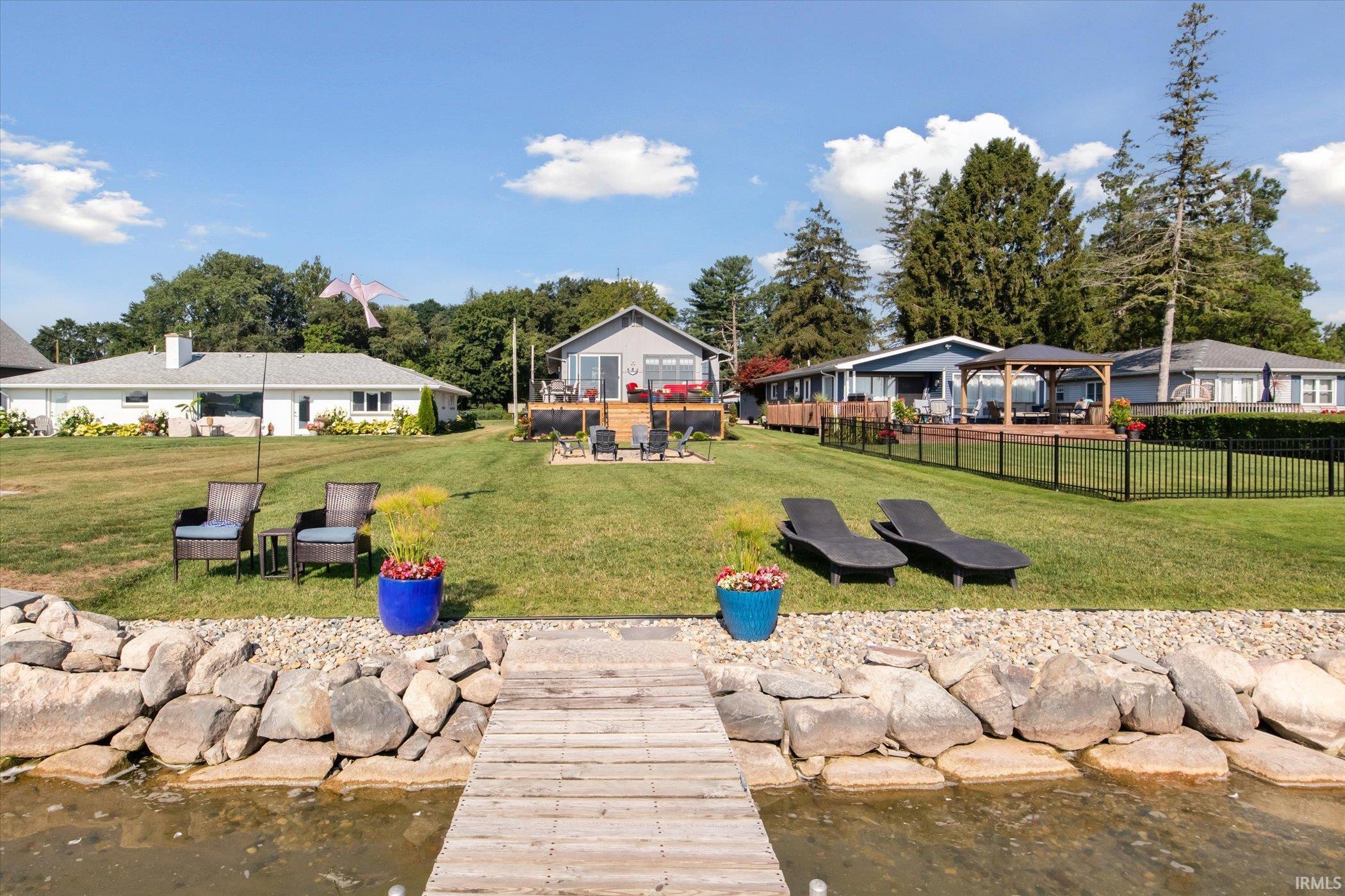Dock featuring a water view, a yard, and a patio