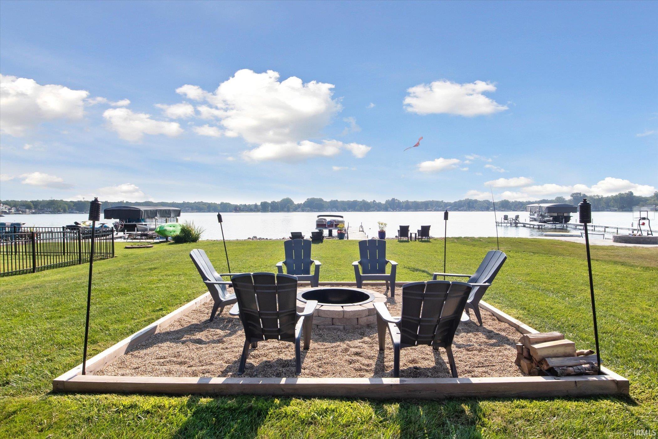 View of yard featuring an outdoor fire pit, a water view, and a patio