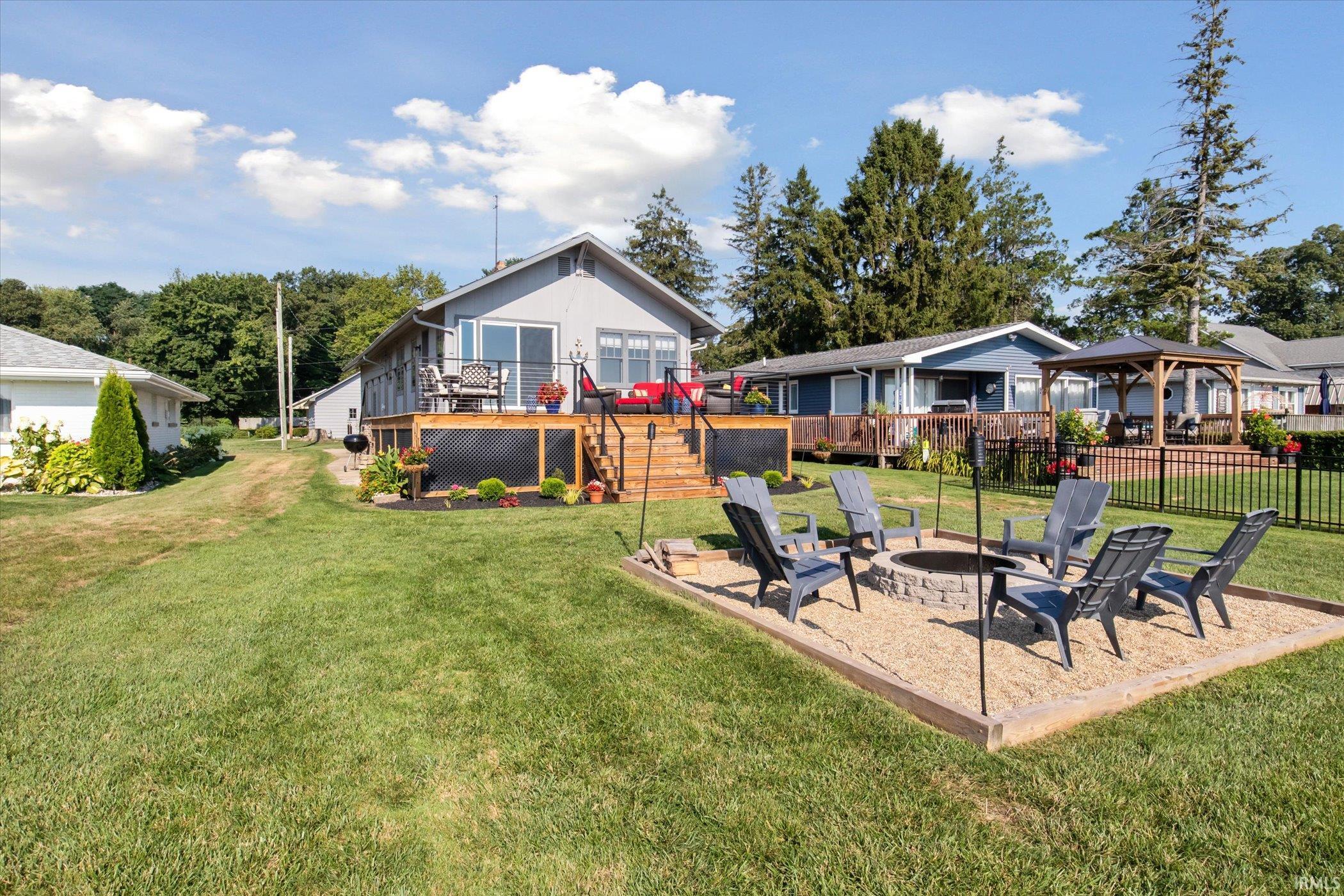 View of yard featuring an outdoor fire pit, a wooden deck, a patio, and stairs