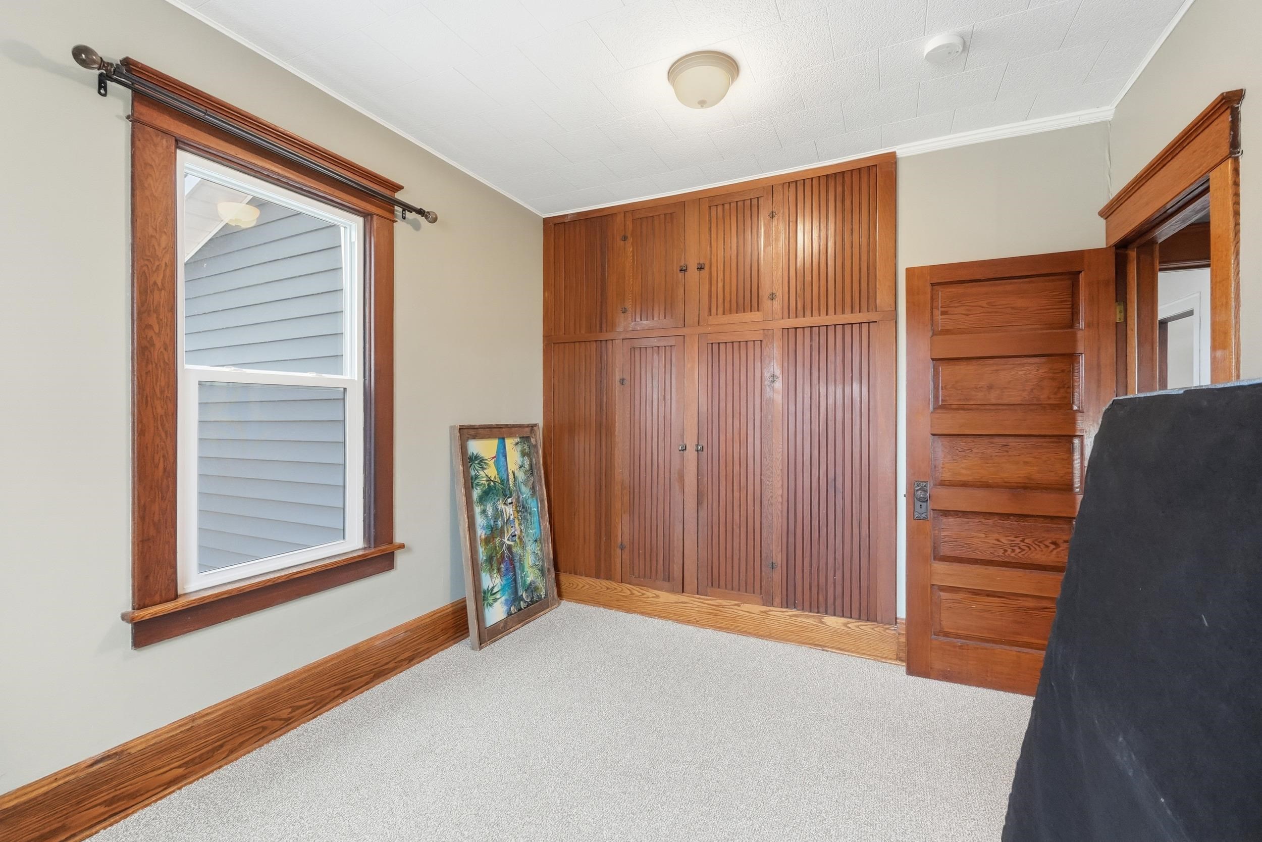 Bedroom featuring a closet, crown molding, and carpet