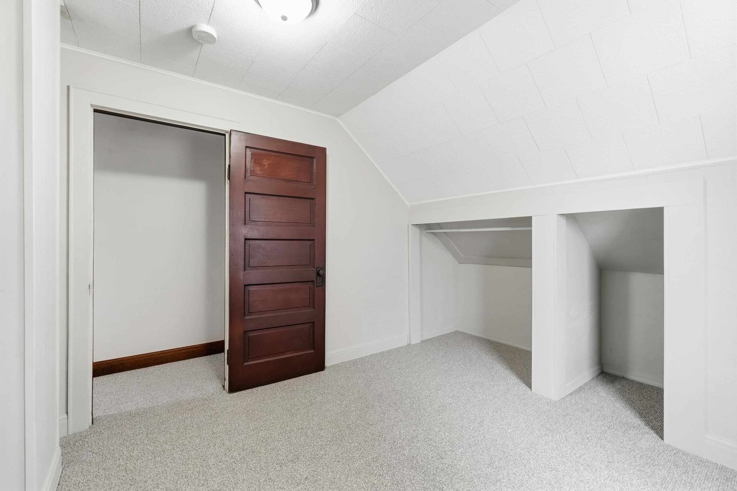 Additional living space with light carpet and lofted ceiling