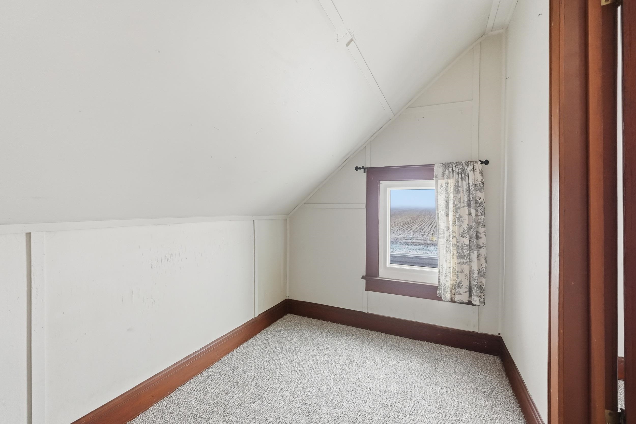 Additional living space featuring vaulted ceiling and carpet floors