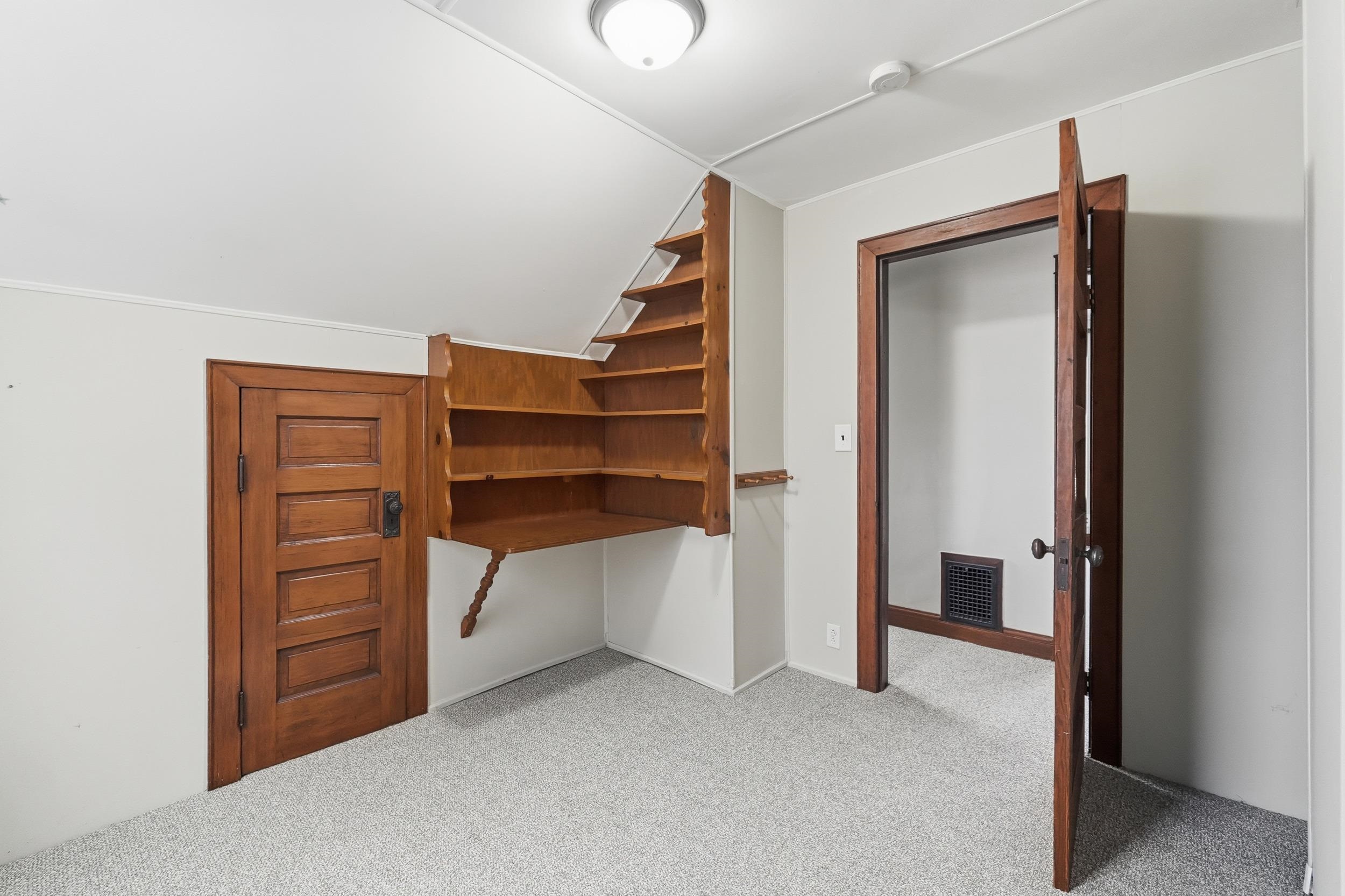 Unfurnished bedroom with vaulted ceiling and light carpet