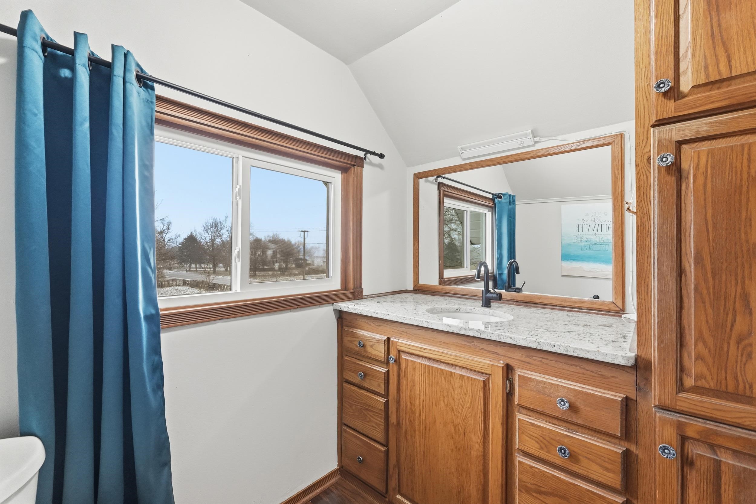 Half bath with vanity and lofted ceiling
