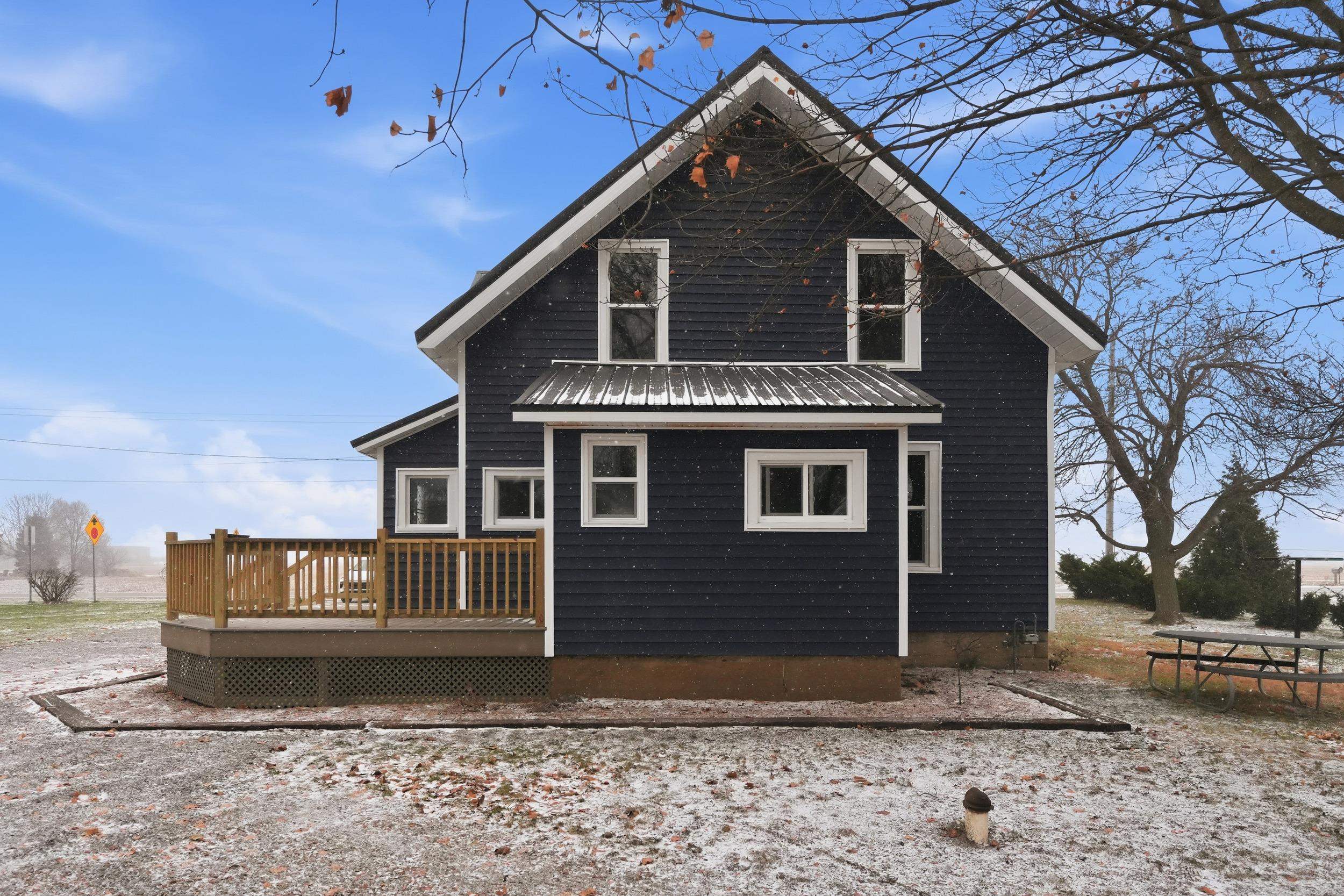 Back of property with a wooden deck and a metal roof