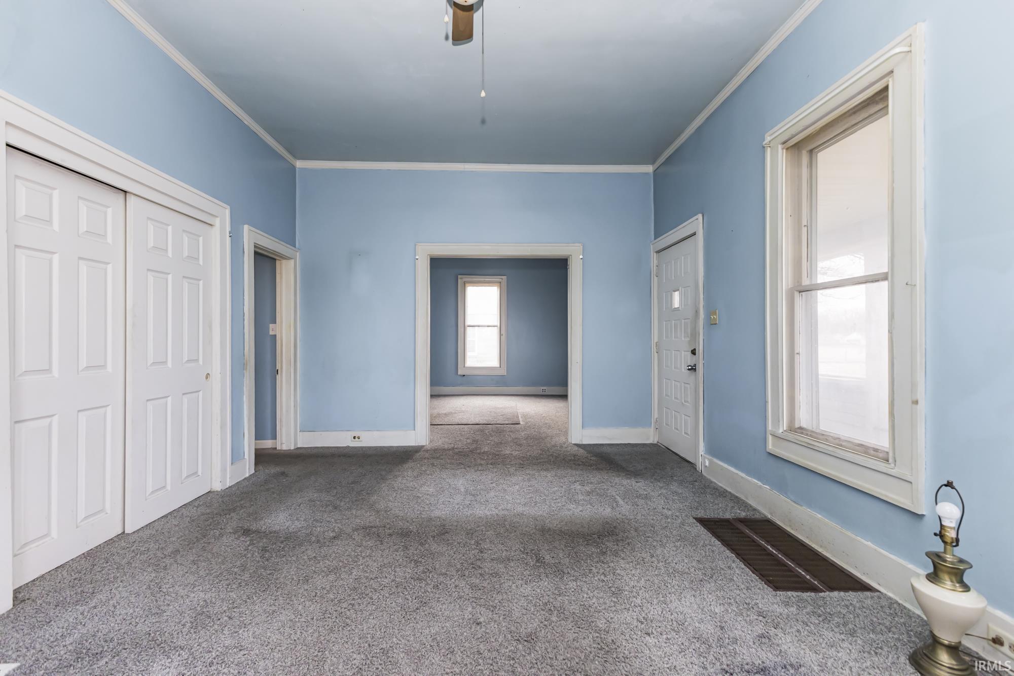 Unfurnished bedroom with carpet flooring, a closet, crown molding, and ceiling fan