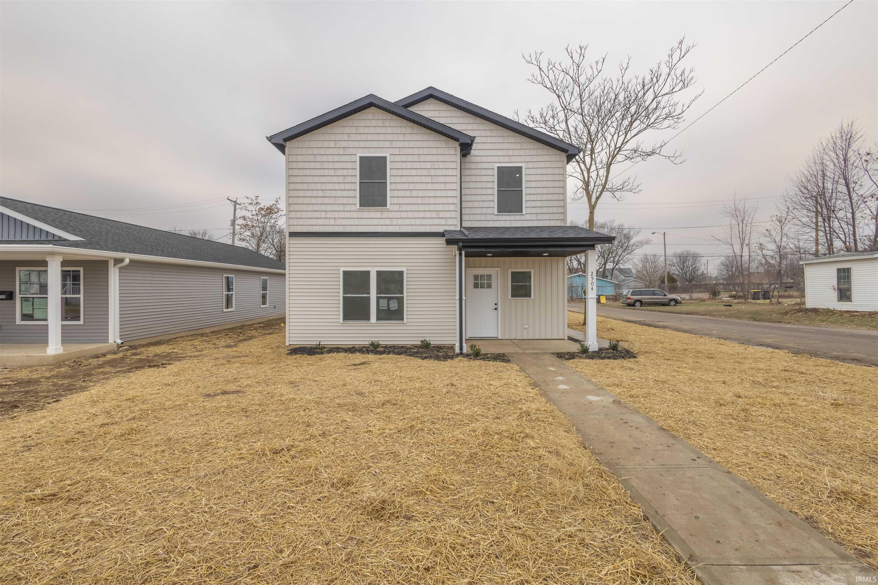 View of front of house featuring covered porch and a front yard