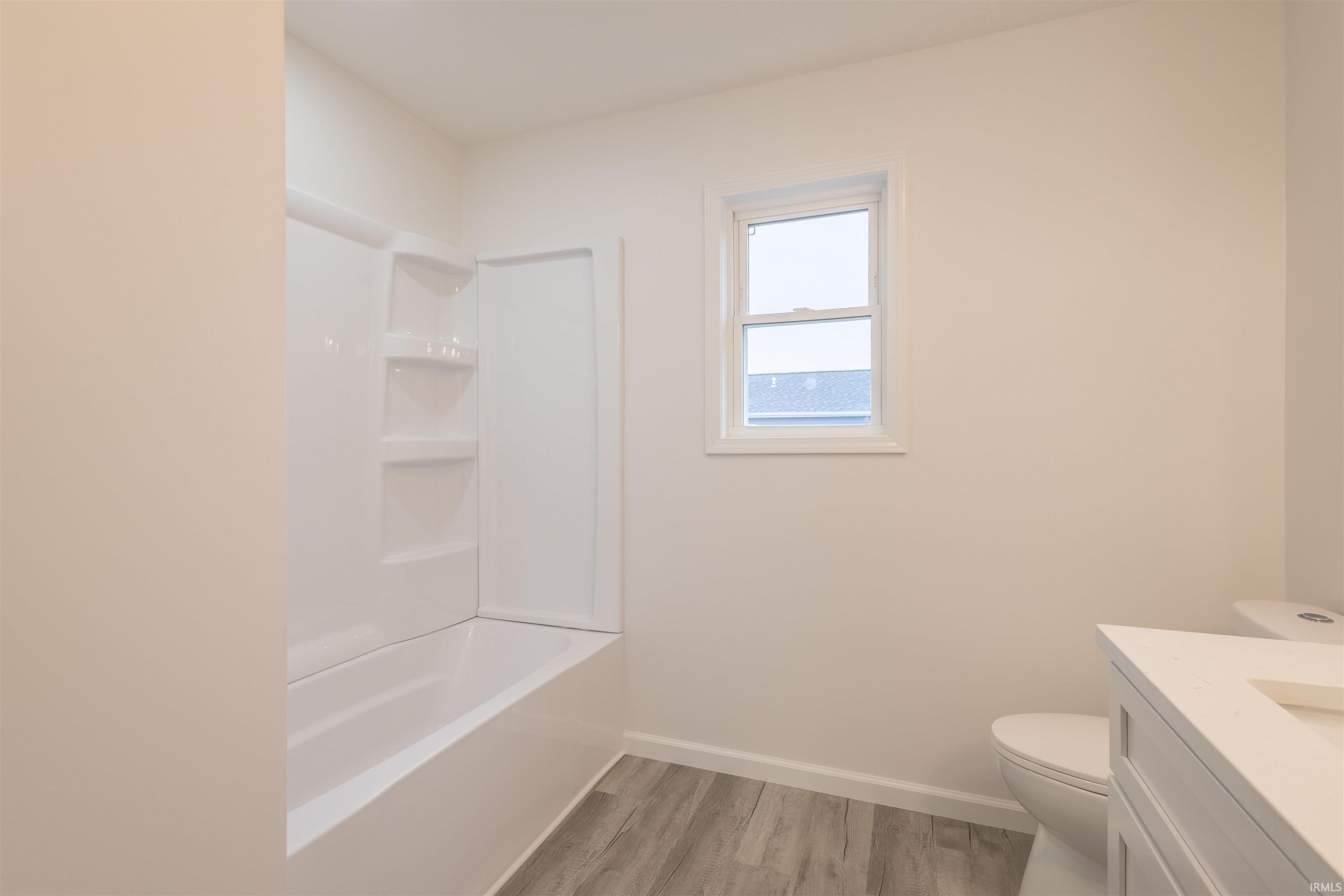 Full bath with vanity, light wood-style flooring, and shower / bath combination