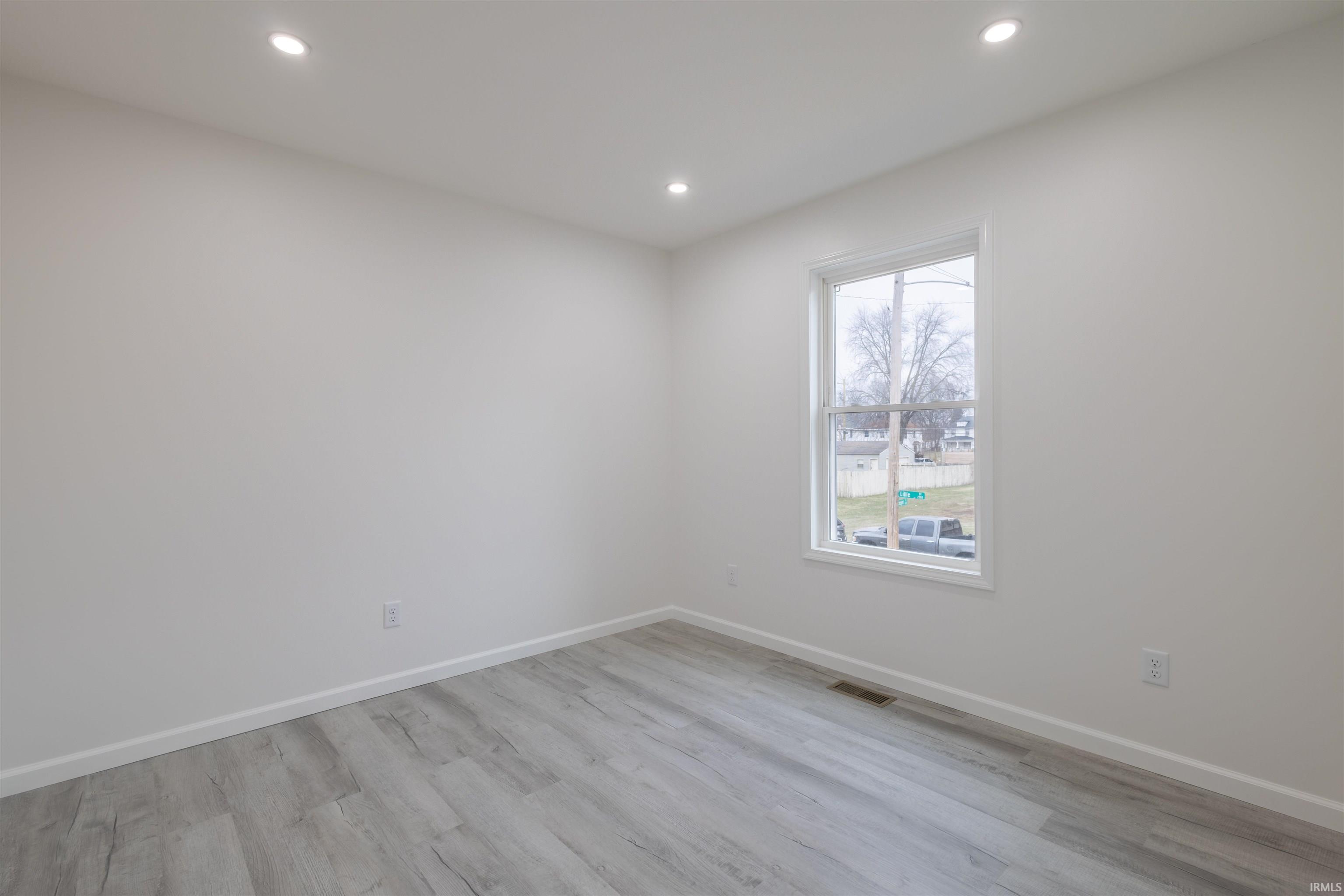 Unfurnished room with light wood-type flooring and recessed lighting
