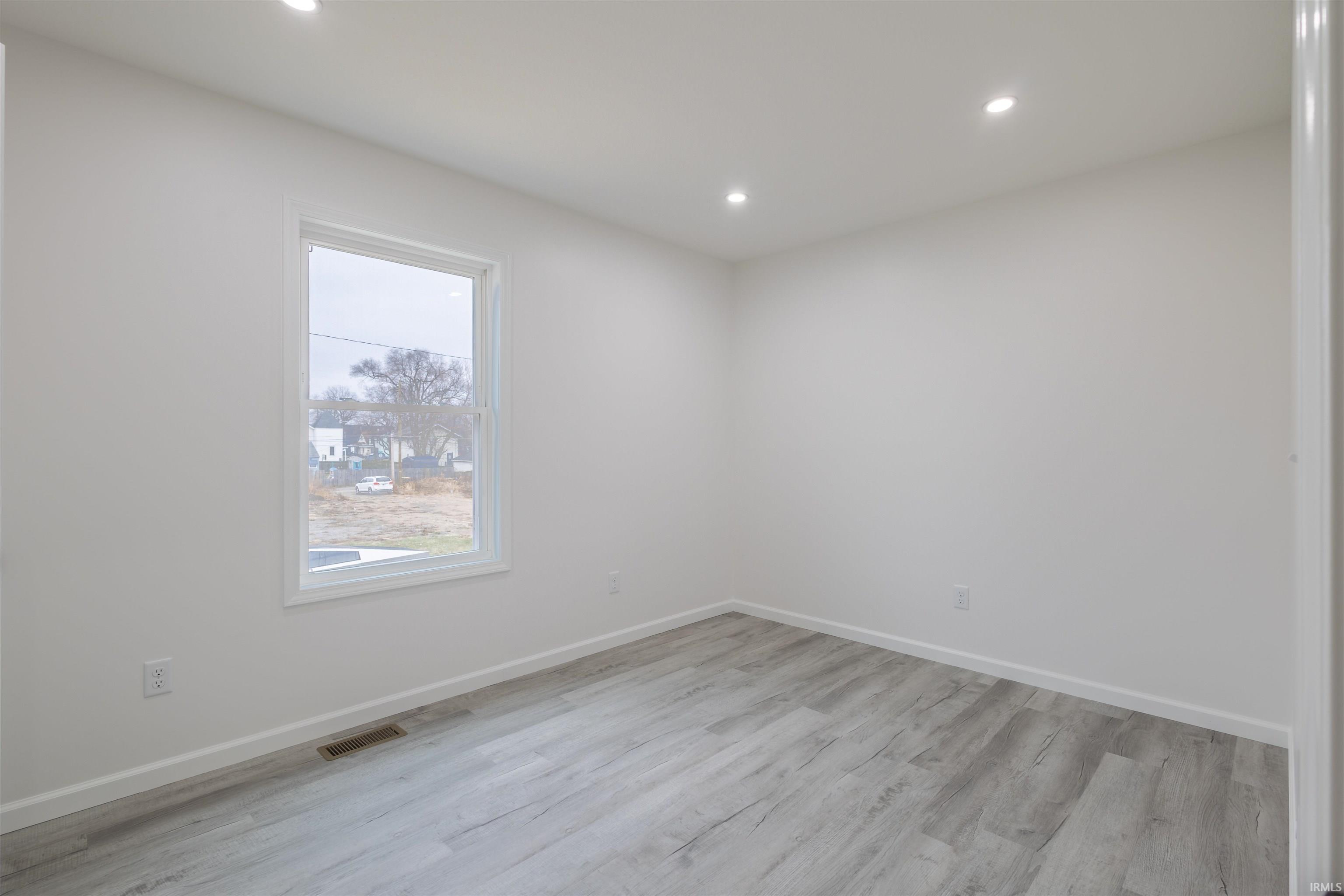 Spare room with light wood-style floors and recessed lighting