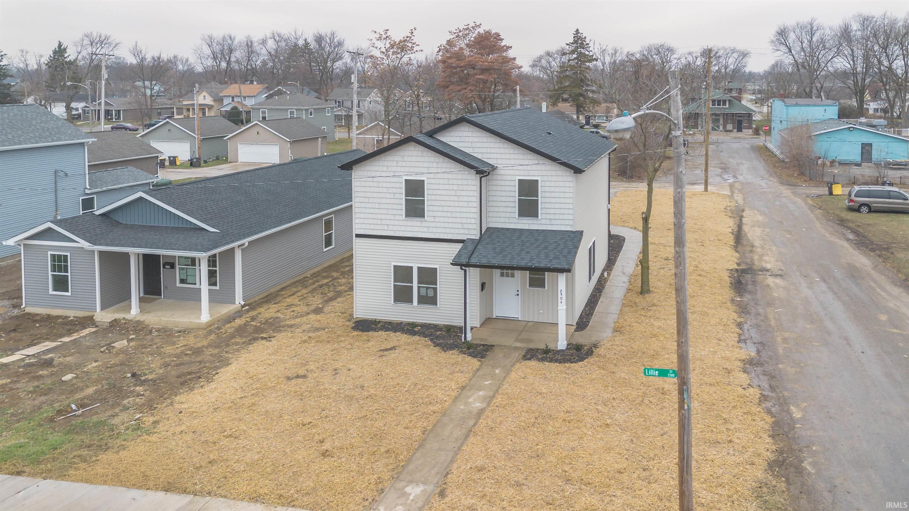 Traditional-style home with a residential view, roof with shingles, and covered porch