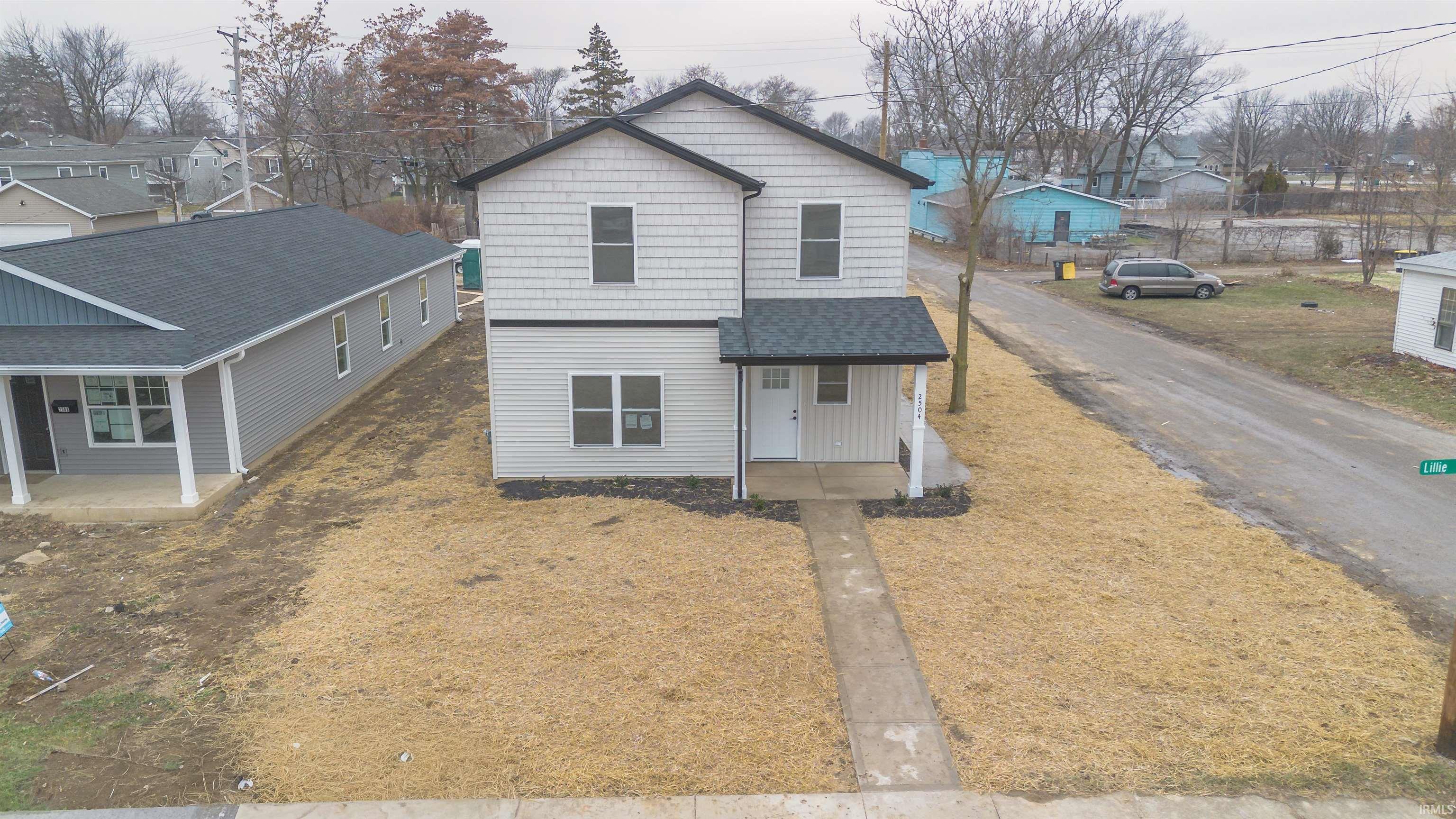 View of front of home featuring a residential view, covered porch, and roof with shingles