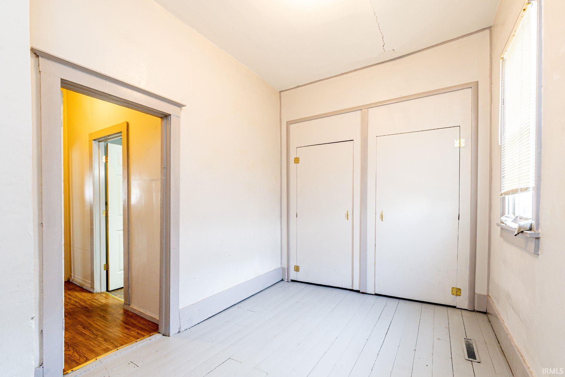 Unfurnished bedroom featuring light wood-style flooring and a closet