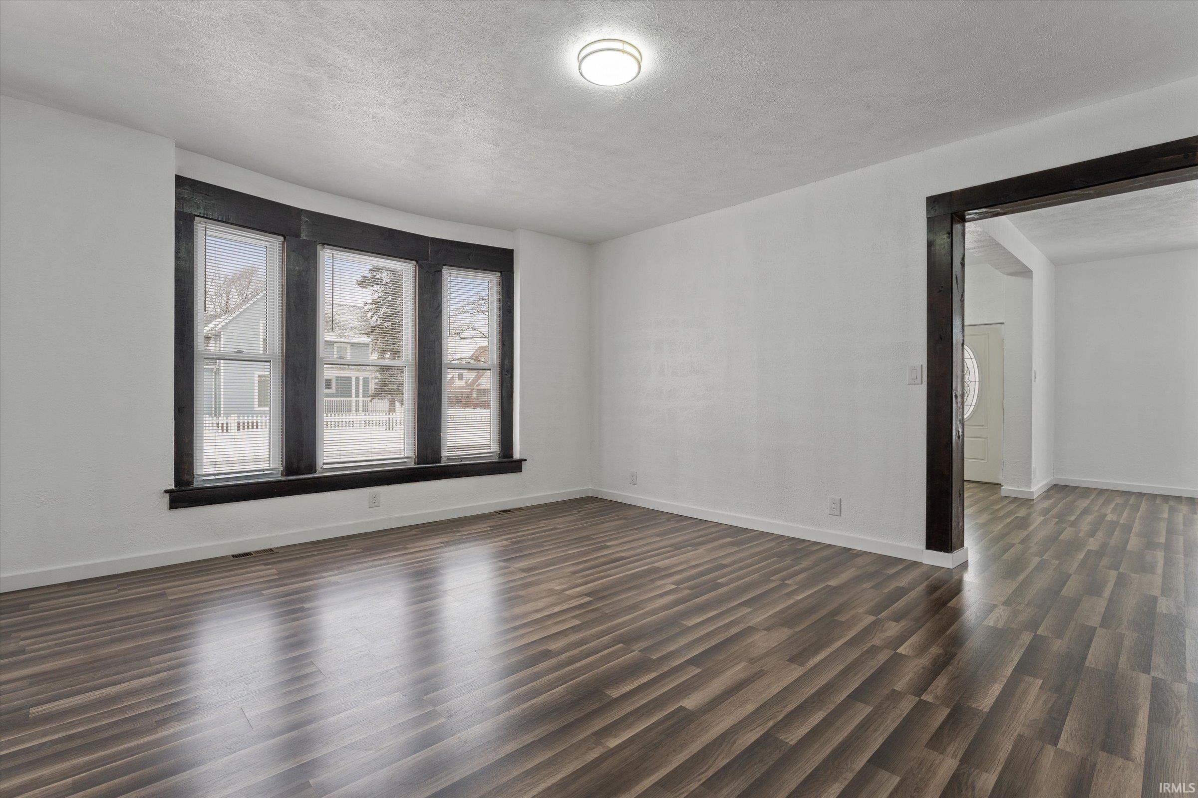 Spare room featuring dark wood-style floors and a textured ceiling