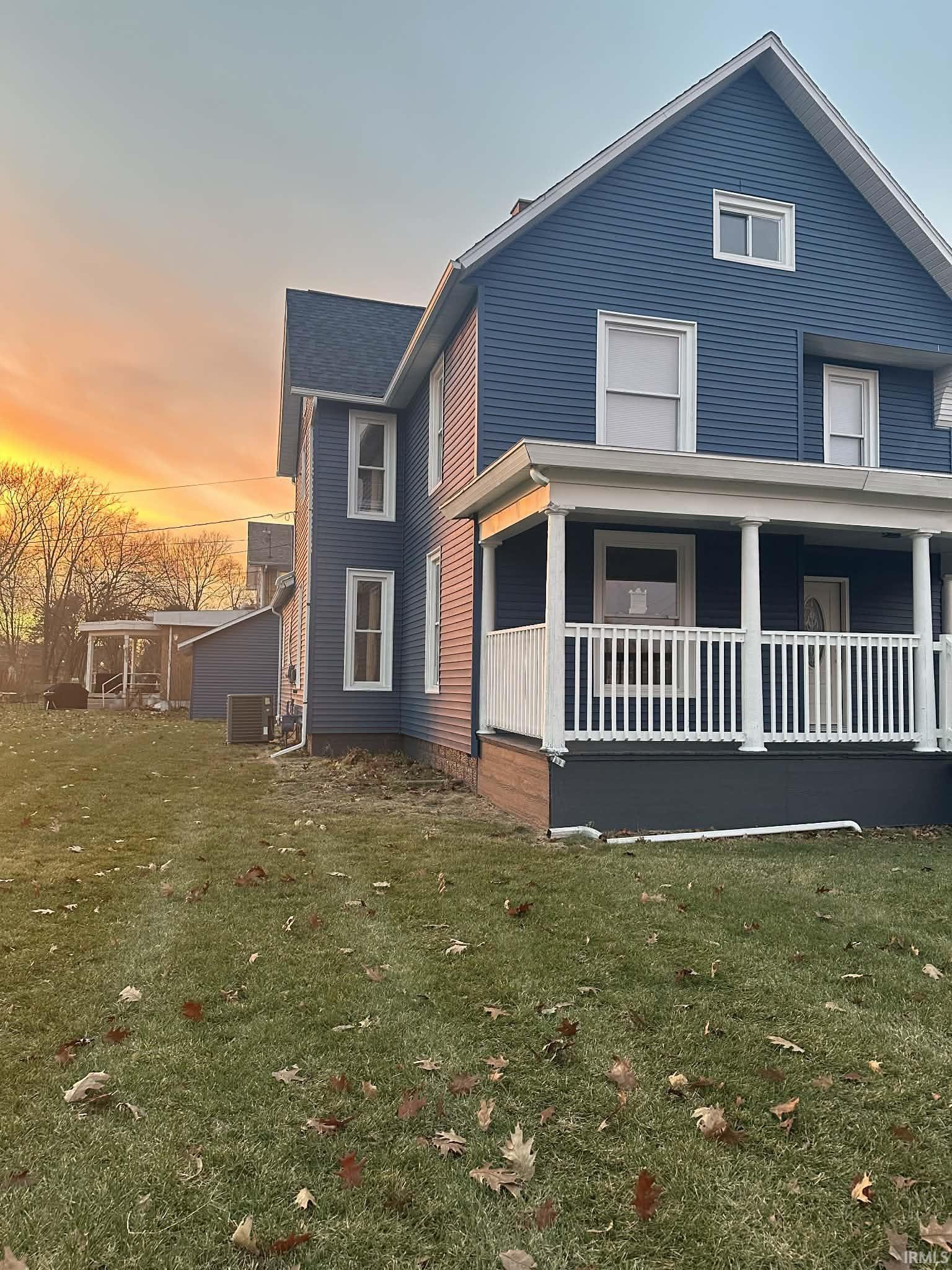View of front facade featuring a front yard and covered porch