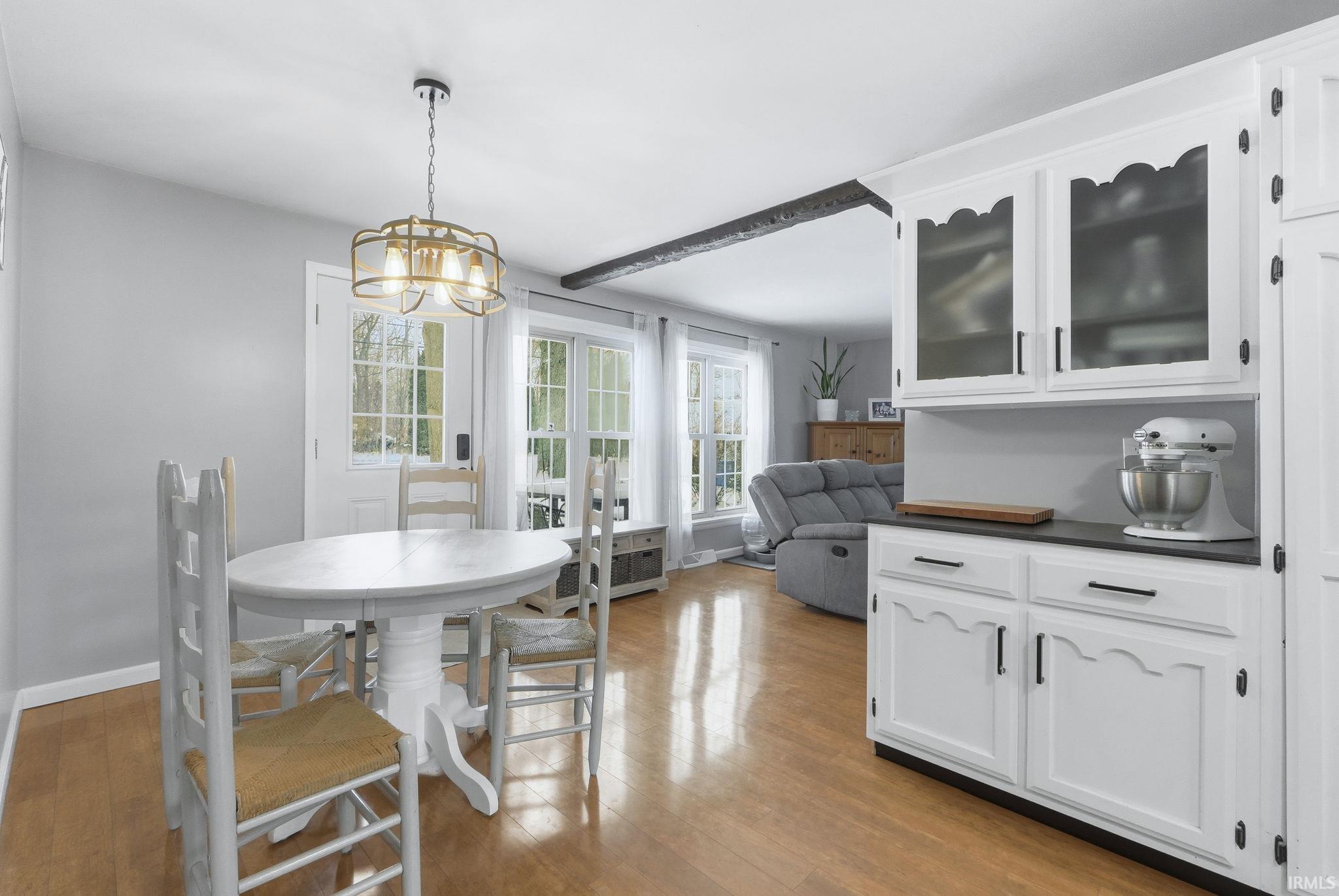 Dining room with light wood finished floors, radiator heating unit, and a chandelier