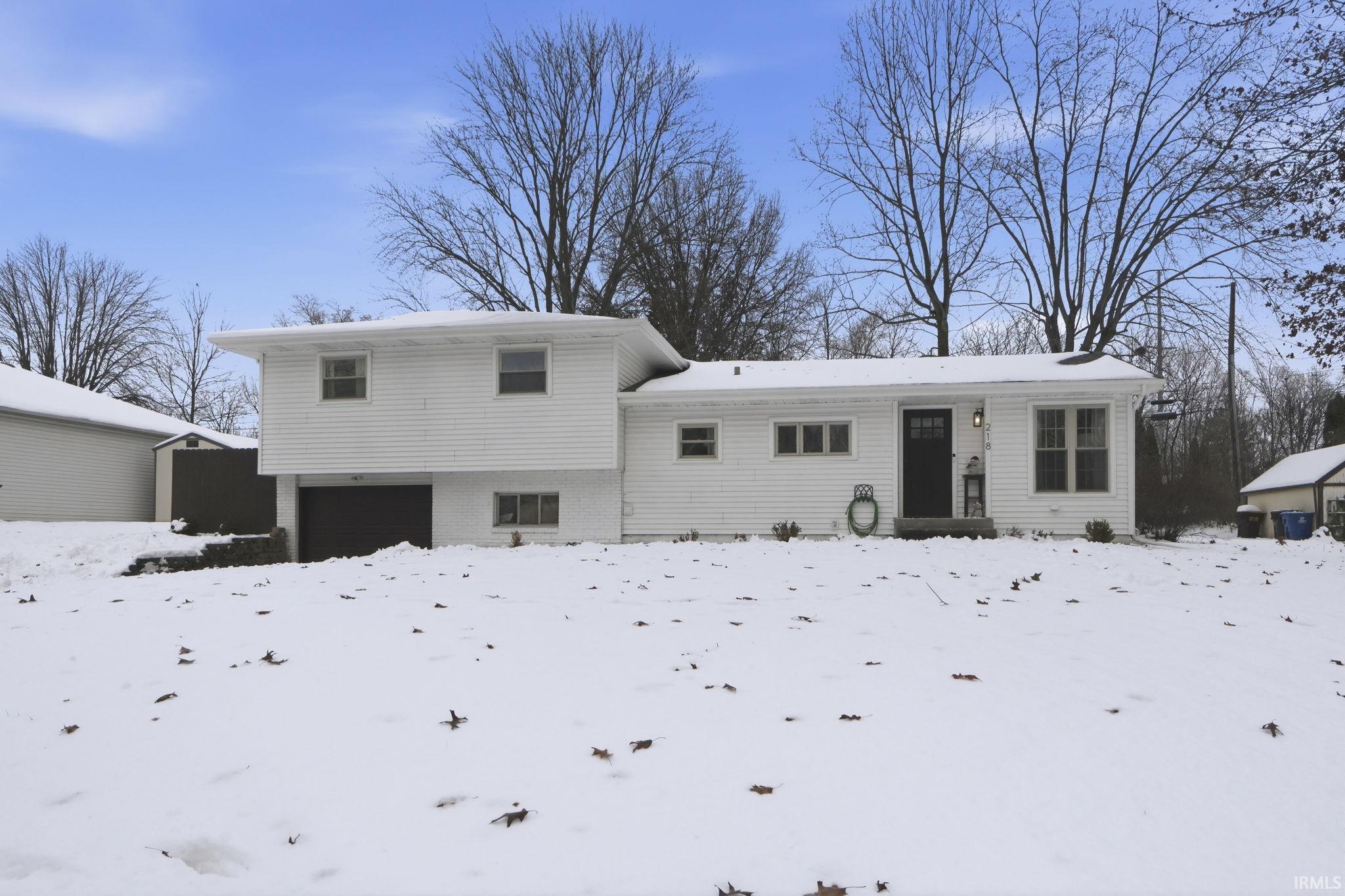 View of front of house with brick siding and a garage