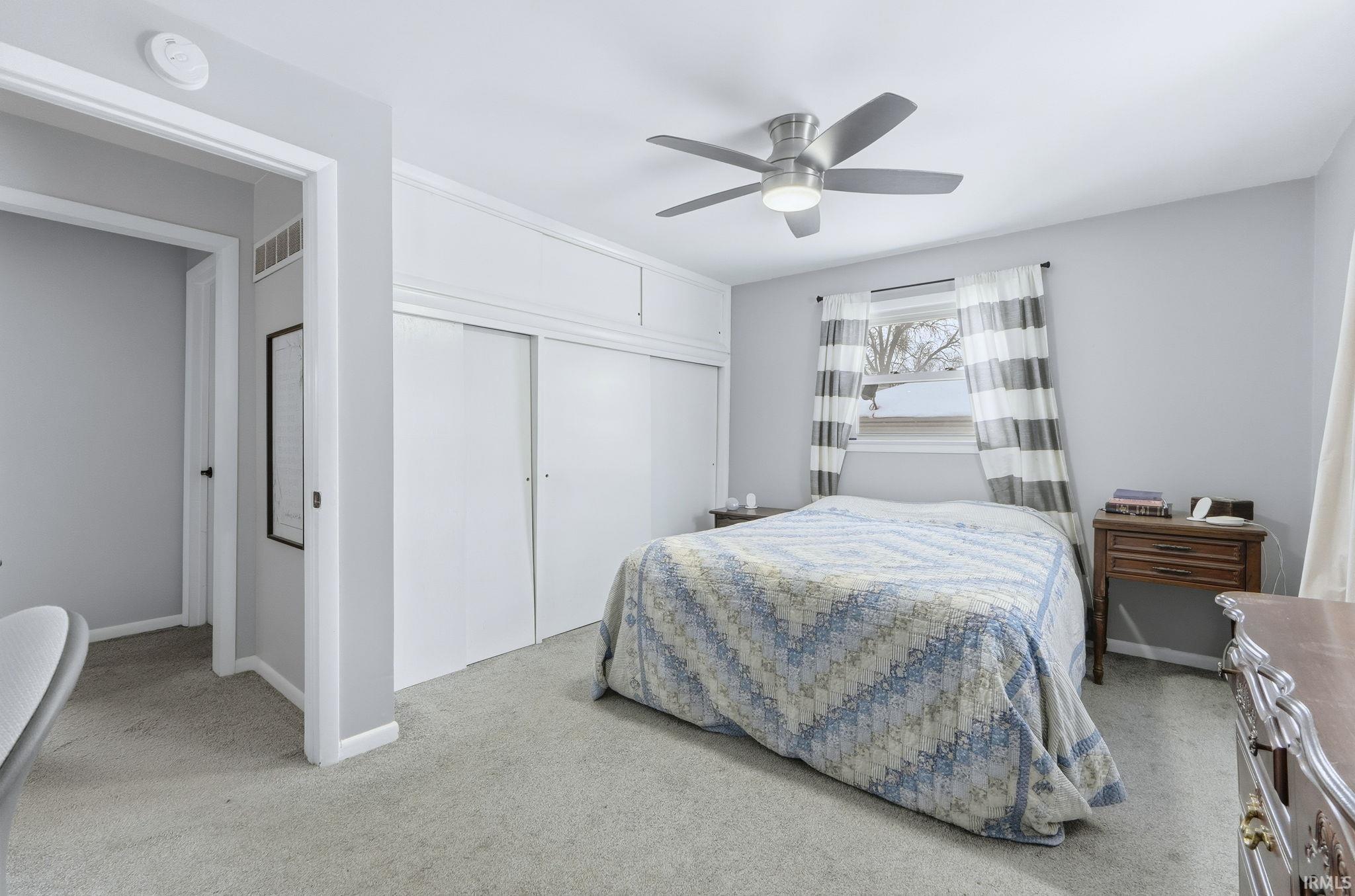 Carpeted bedroom featuring a closet and ceiling fan