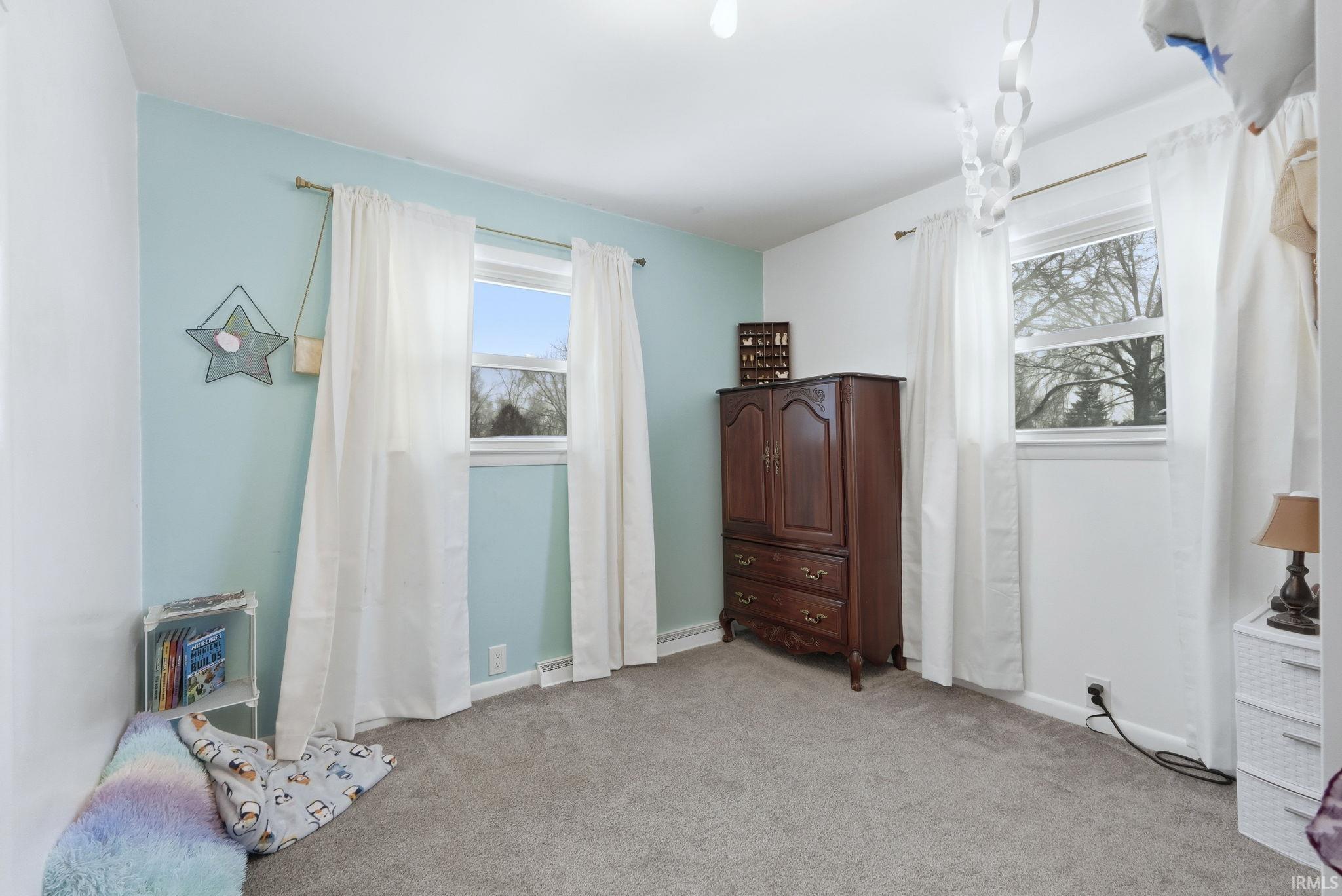Bedroom featuring light carpet and baseboards